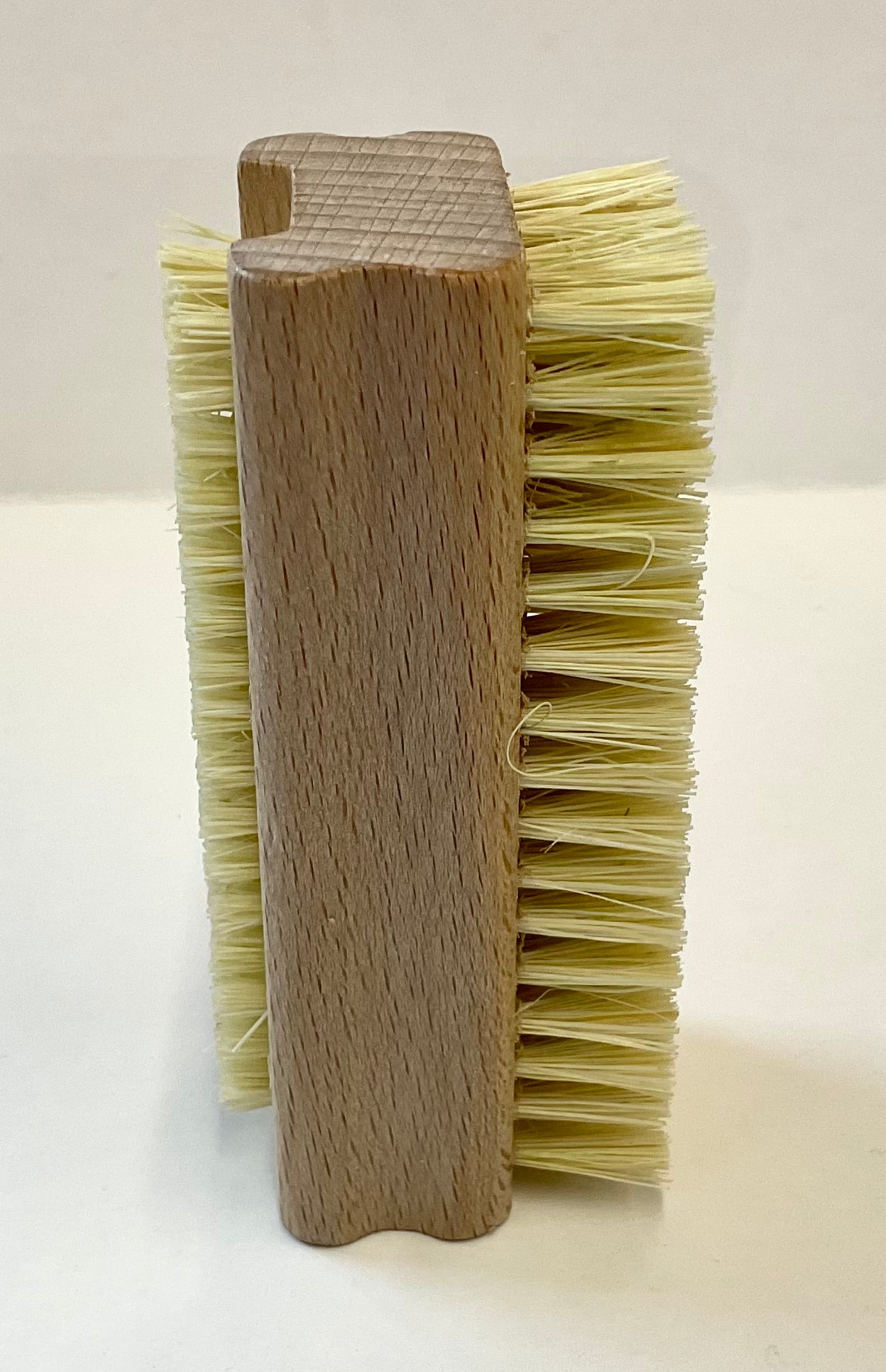 Nail brush with wooden handle and natural bristles on a white background