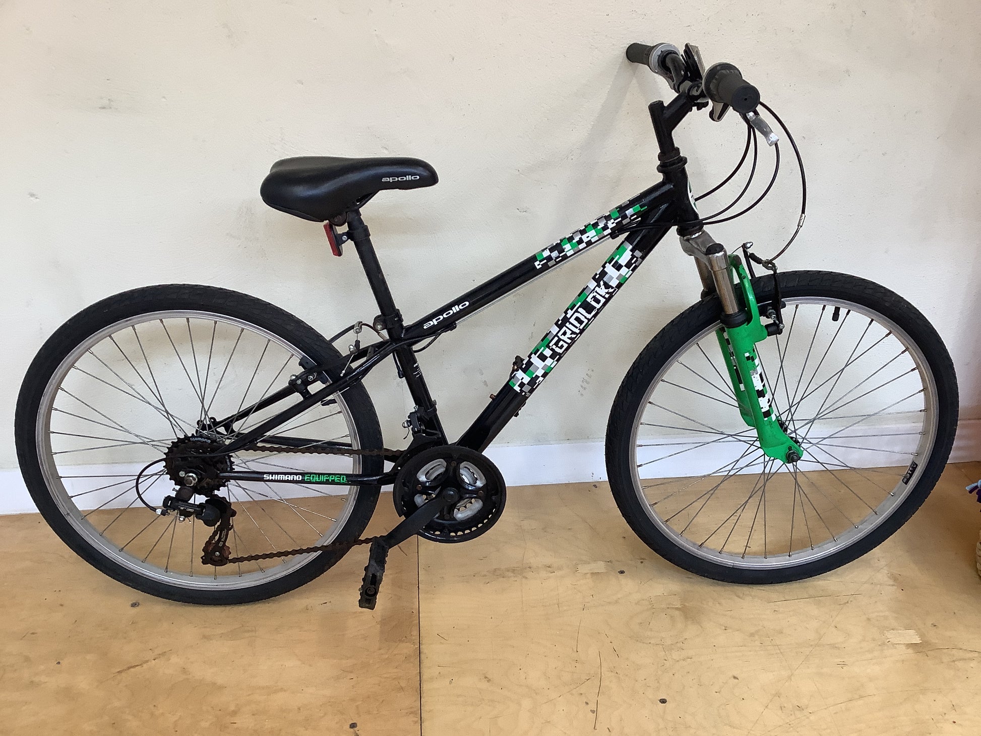 Apollo Gridlock 24" Black bicycle with green accents.