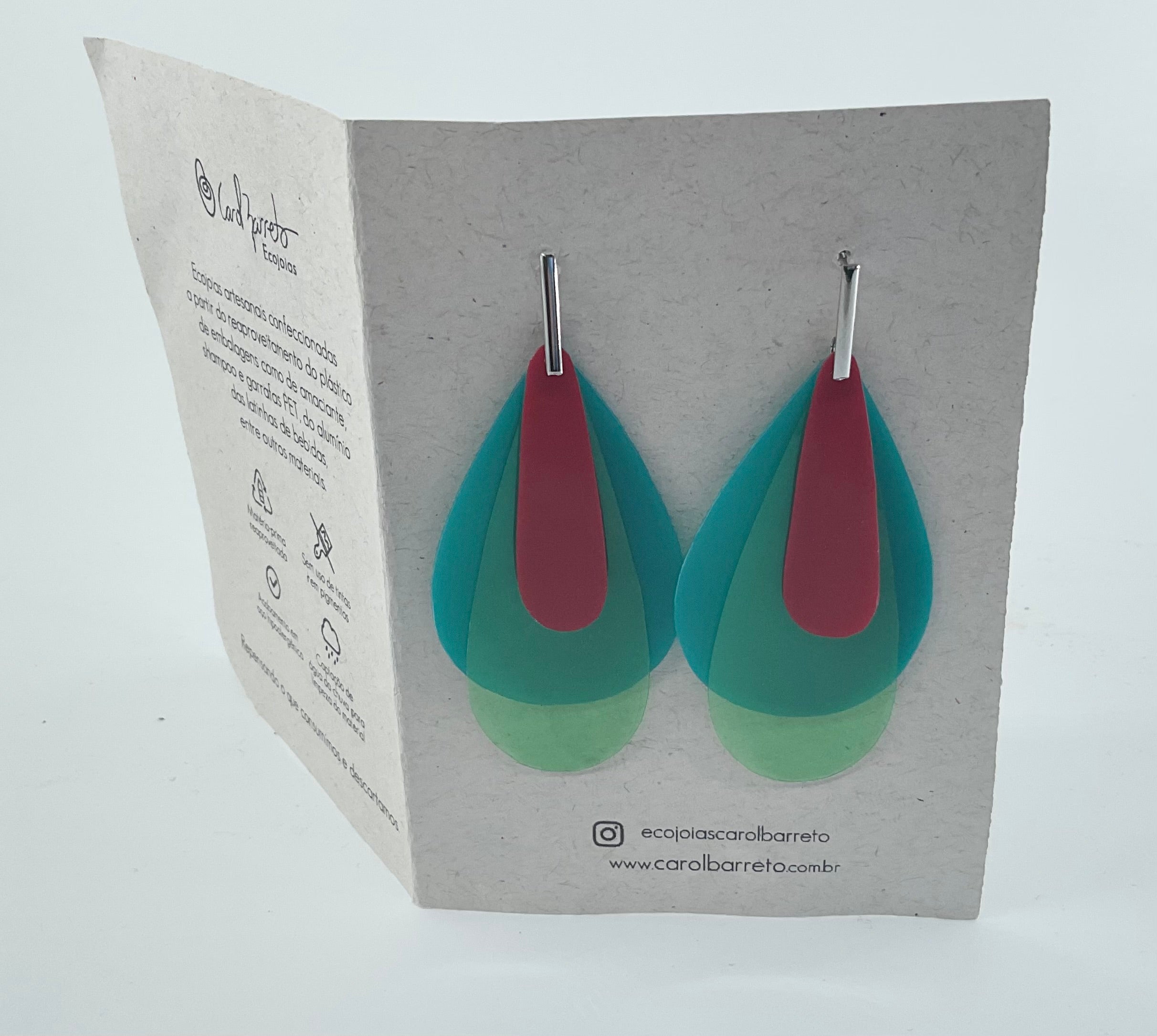 Teal and red earrings on a branded card with visible branding.