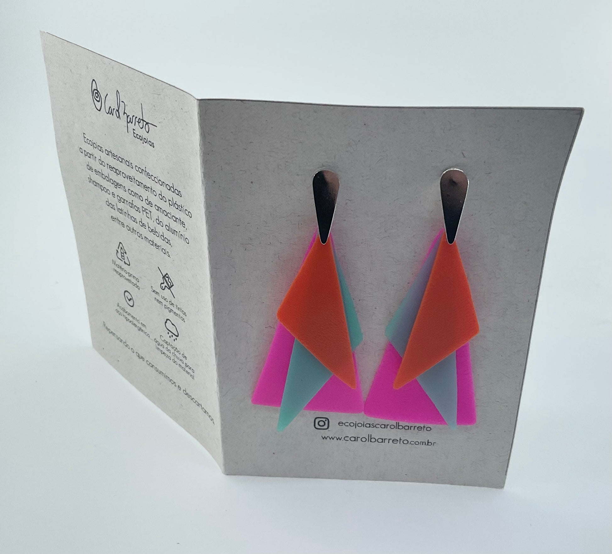 Geometric earrings on a branded card with a white background