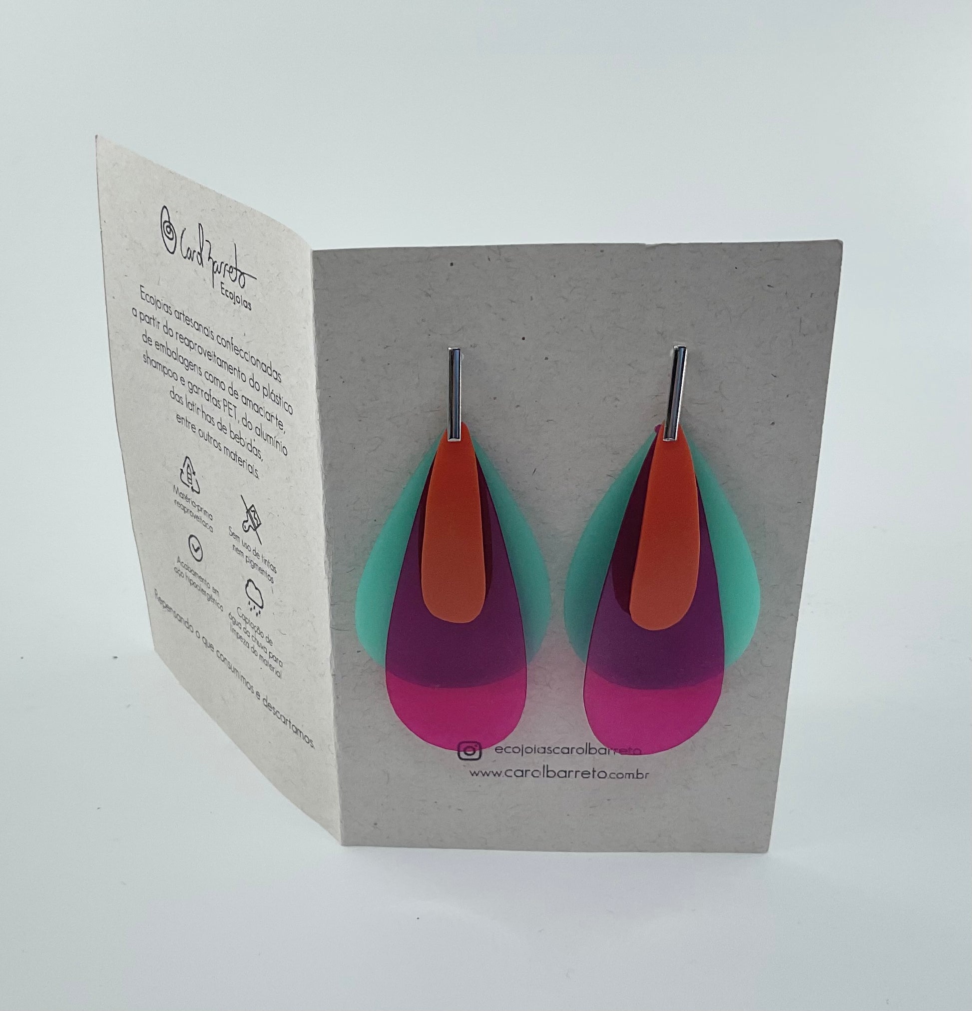 Colorful earrings on a display card with brand information.