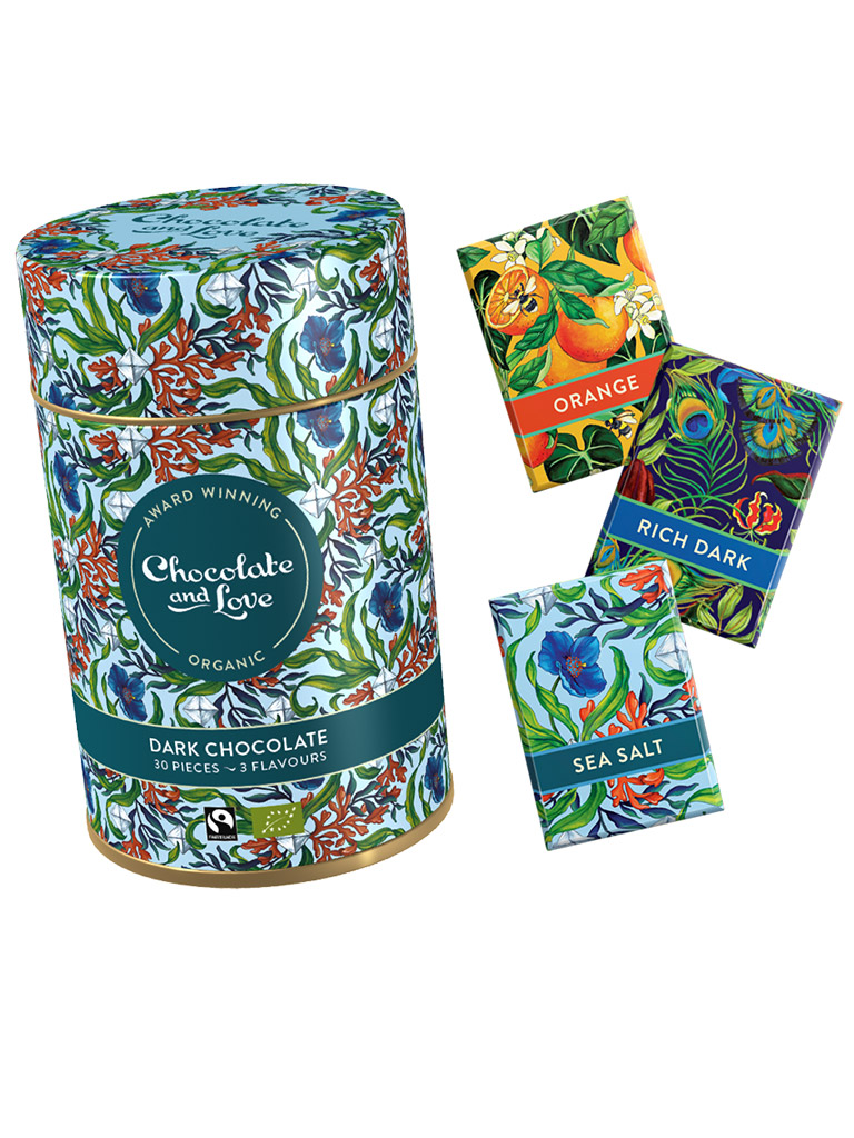Decorative chocolate tin with colorful packaging and three small packets on a white background