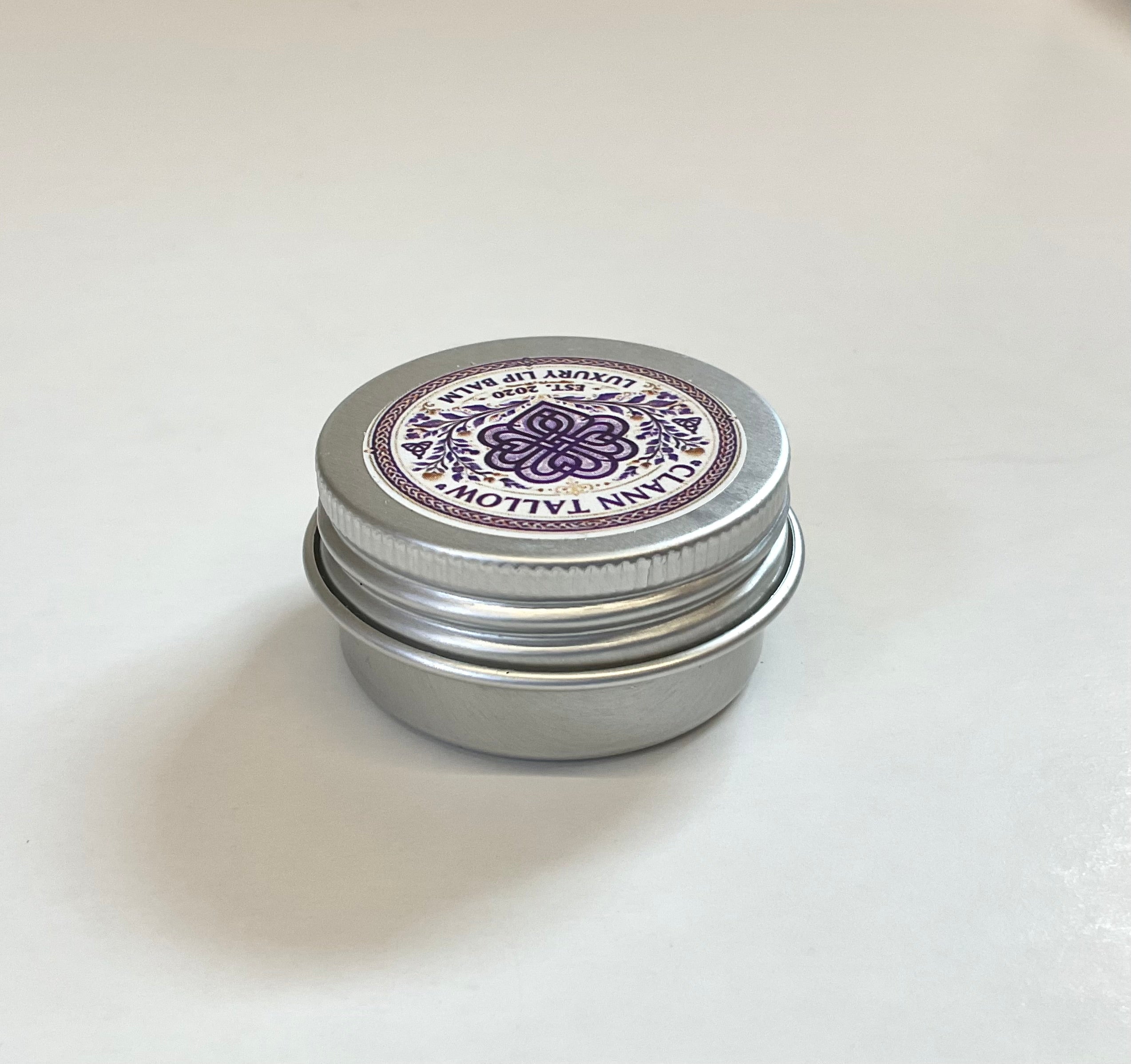 Silver metal tin with decorative purple label on a white background