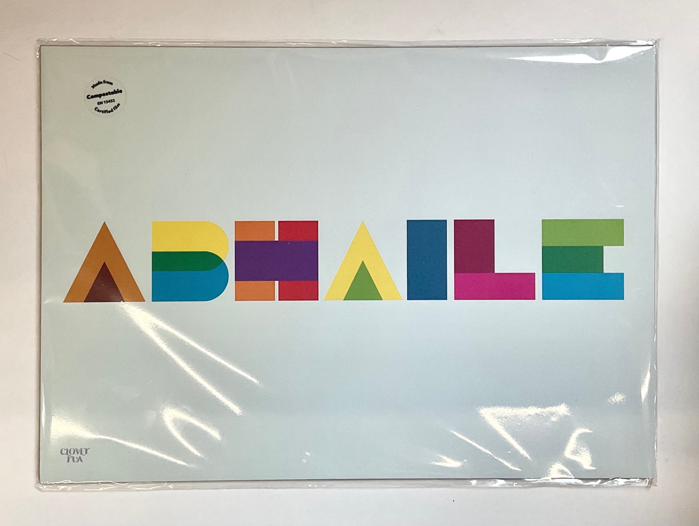 Colorful geometric lettering on a clear plastic cover with a white background