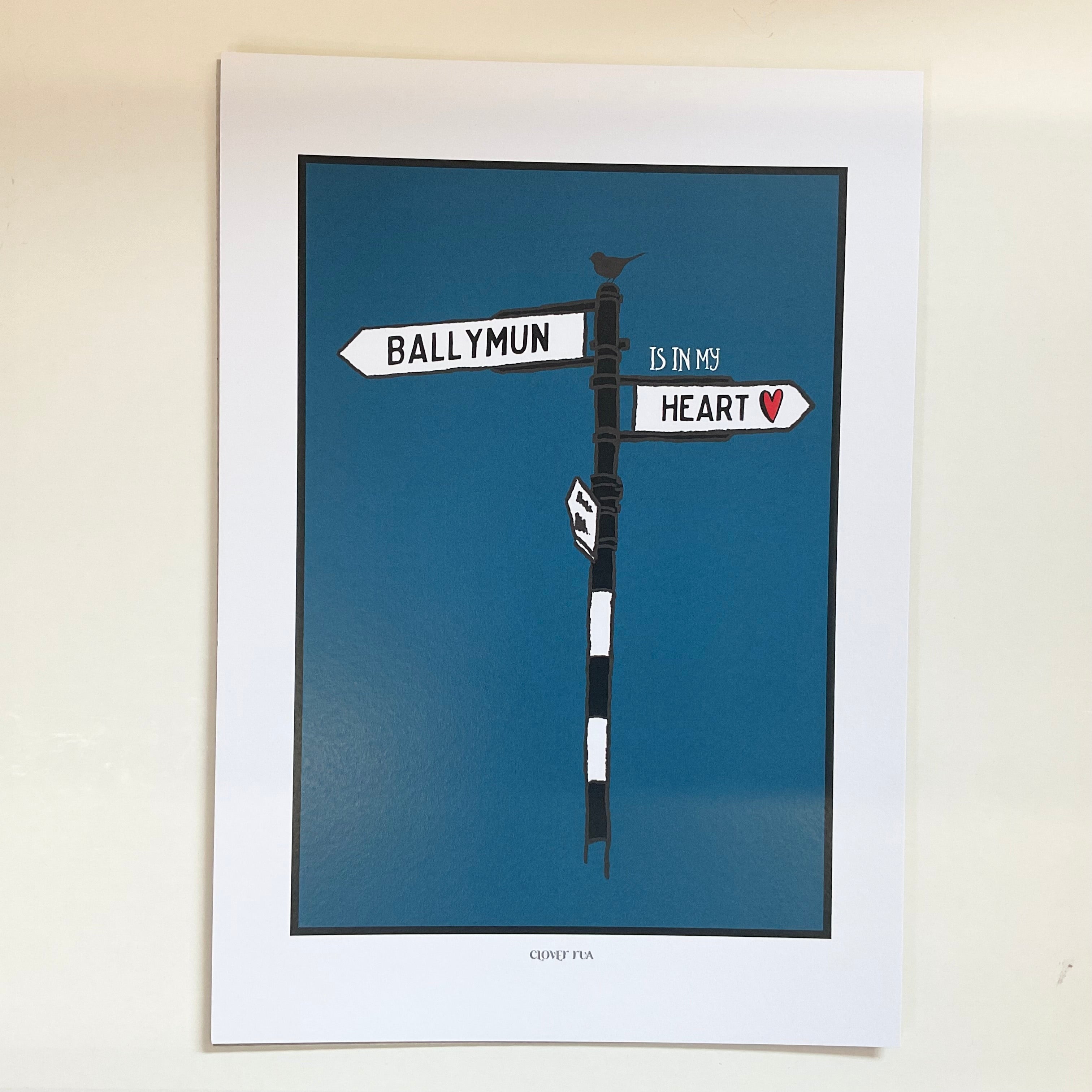 Framed artwork of a street sign with 'Ballymun is in my heart' text on a blue background.
