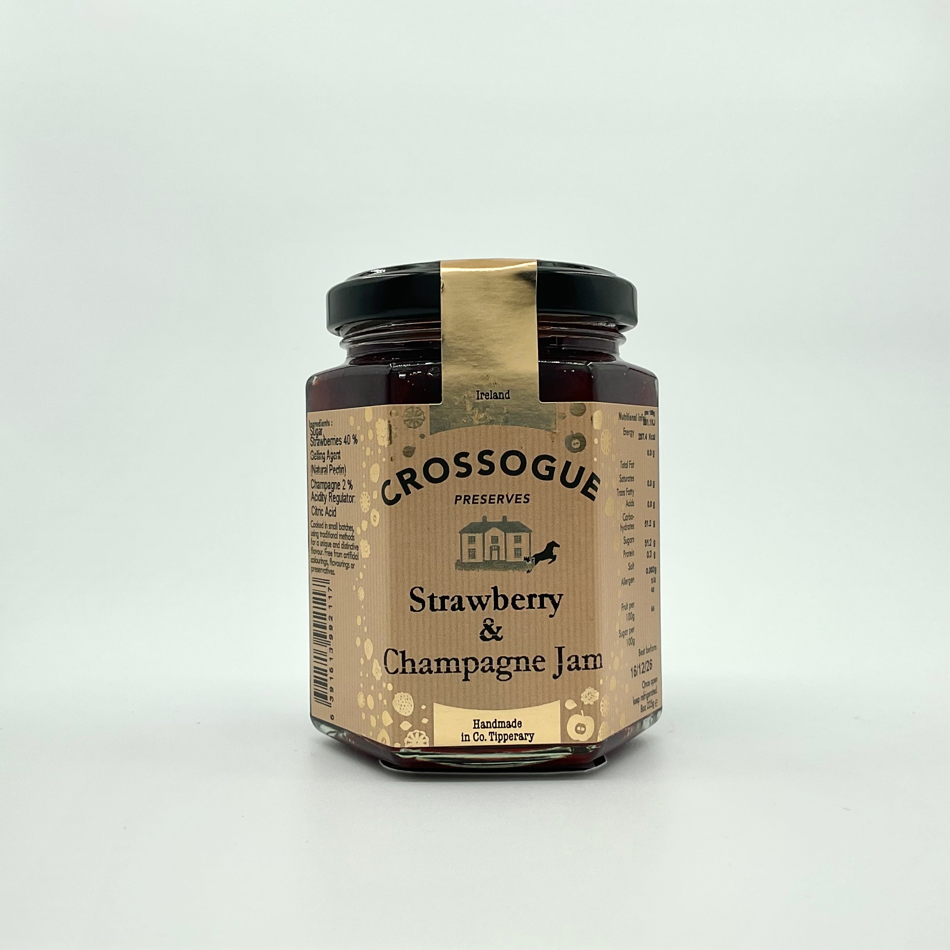 A jar of Crossogue Strawberry & Champagne Jam with a label that includes the product name and information about the product being hand made in small batches.