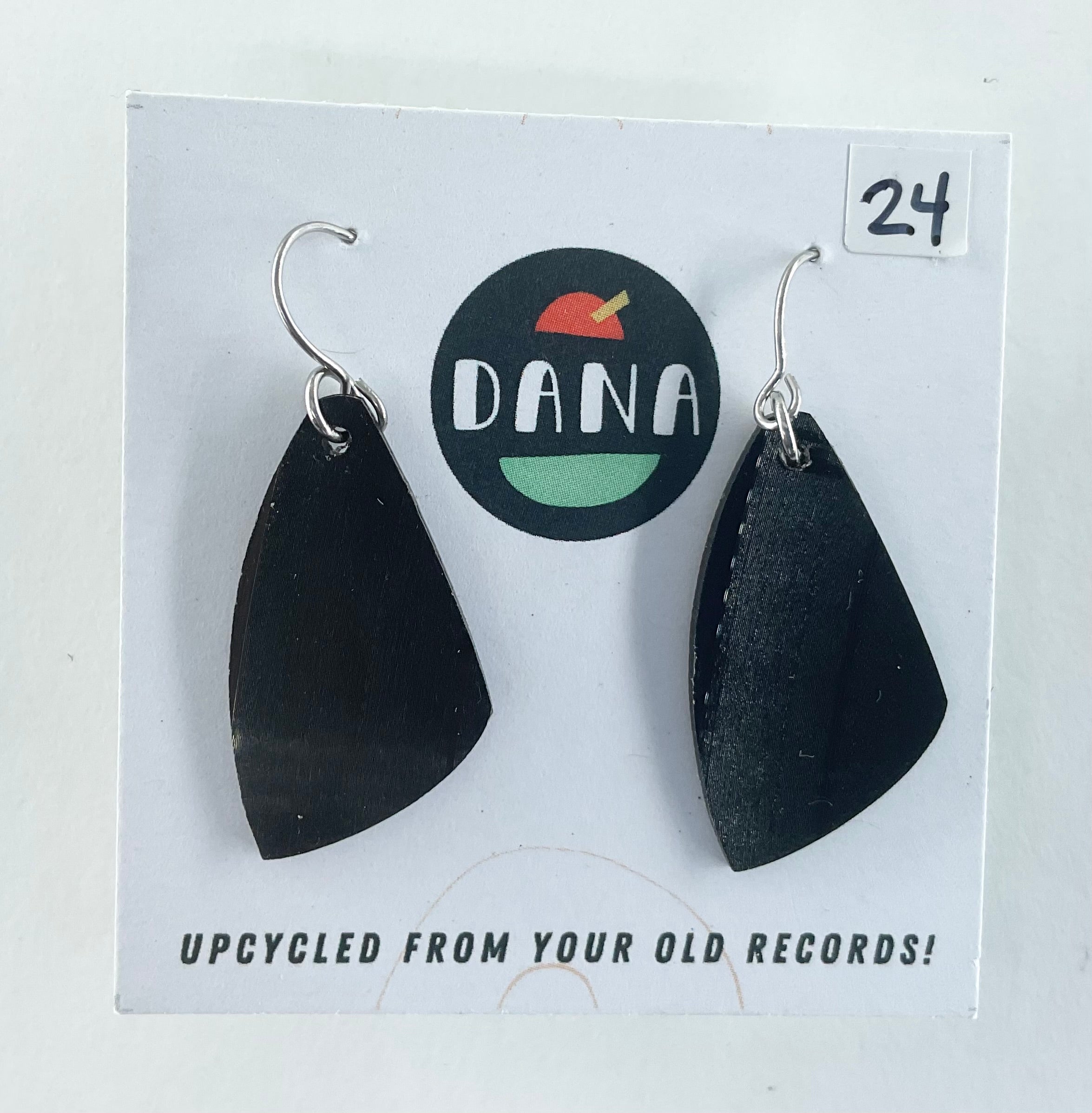 Black earrings on a card with 'Dana' branding and text about upcycling from records.