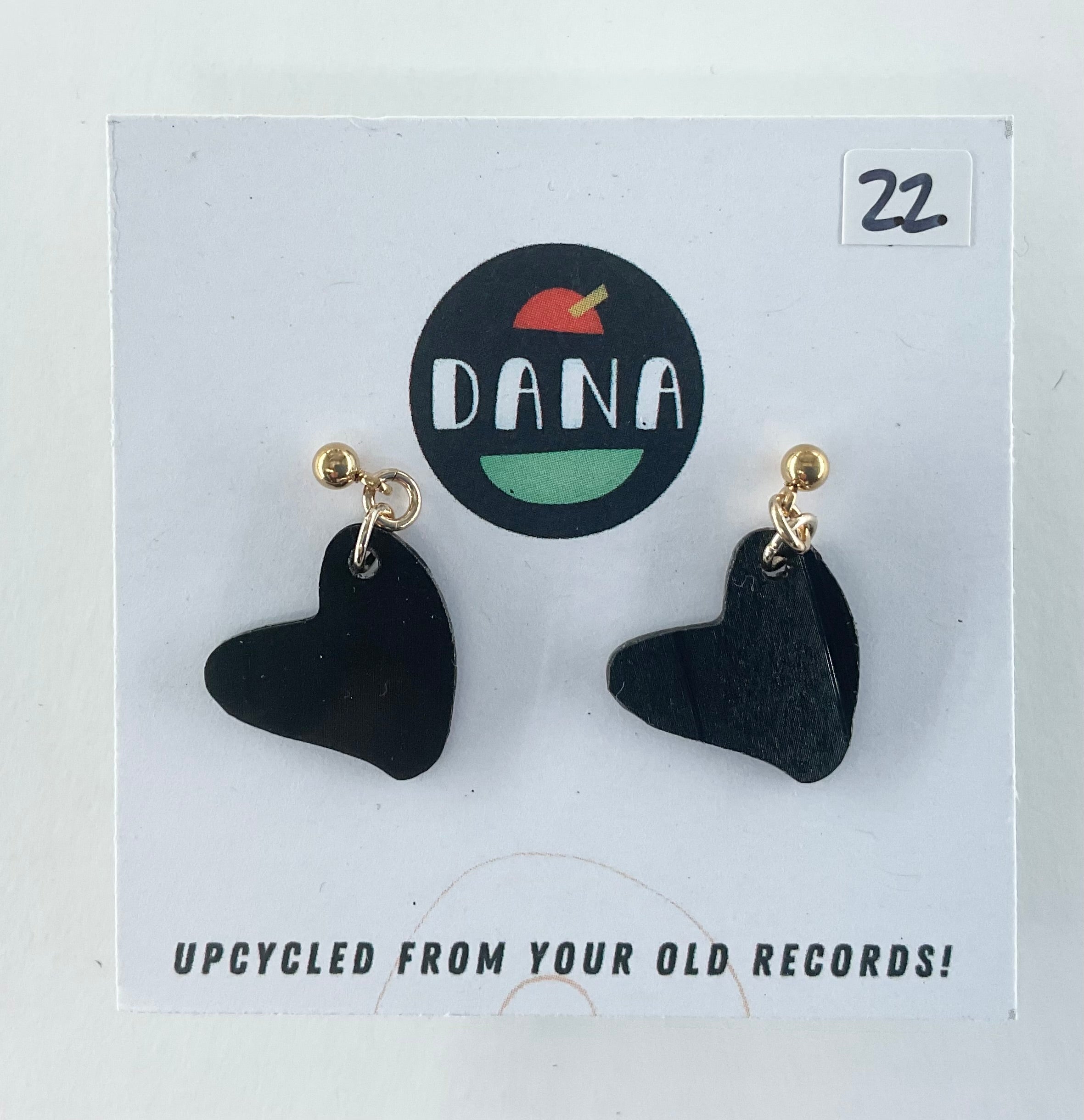 Black heart-shaped earrings on a Dana branded card with 'Upcycled from your old records!' text.