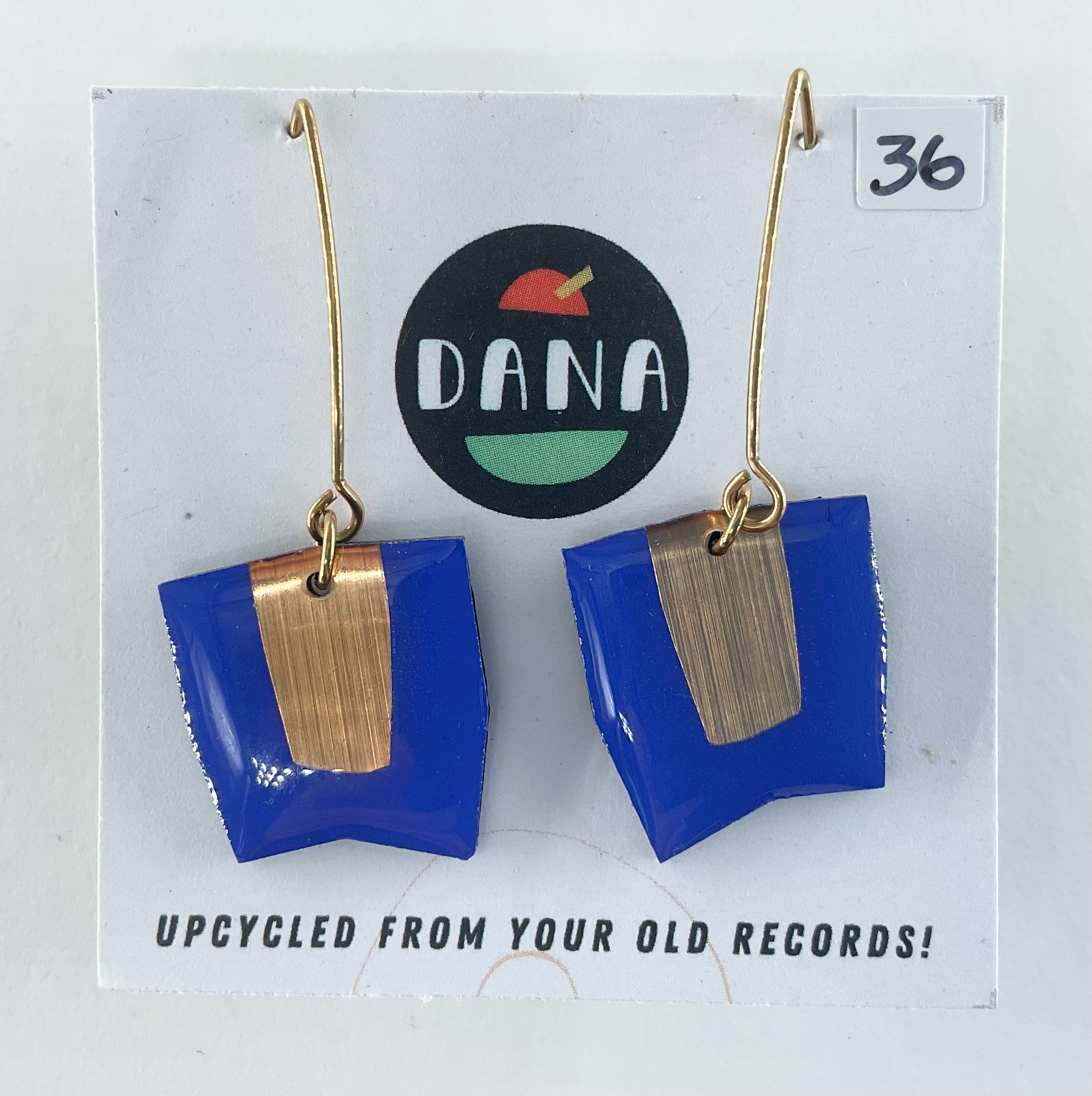 Blue and gold earrings on a card with 'DANA' branding and text about upcycling from old records.