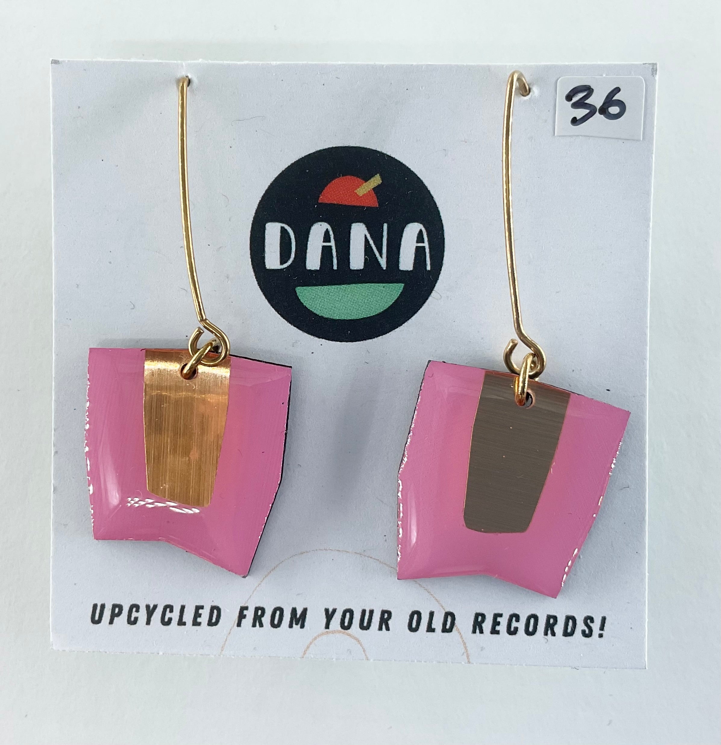 Pink and gold earrings on a card with 'DANA' branding and text about upcycling from old records.