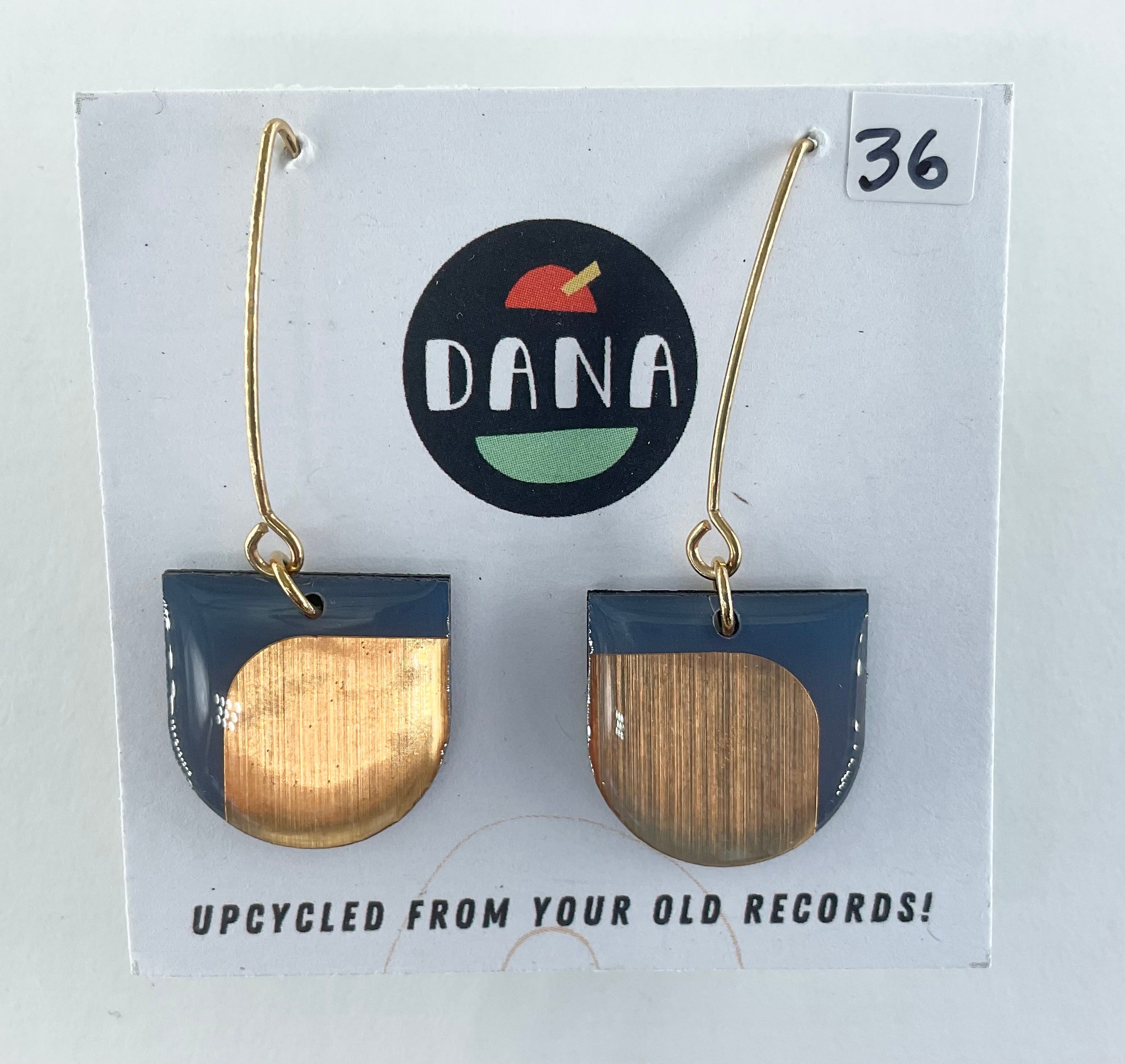 Earrings on a card with 'DANA' branding and text about upcycling from old records.