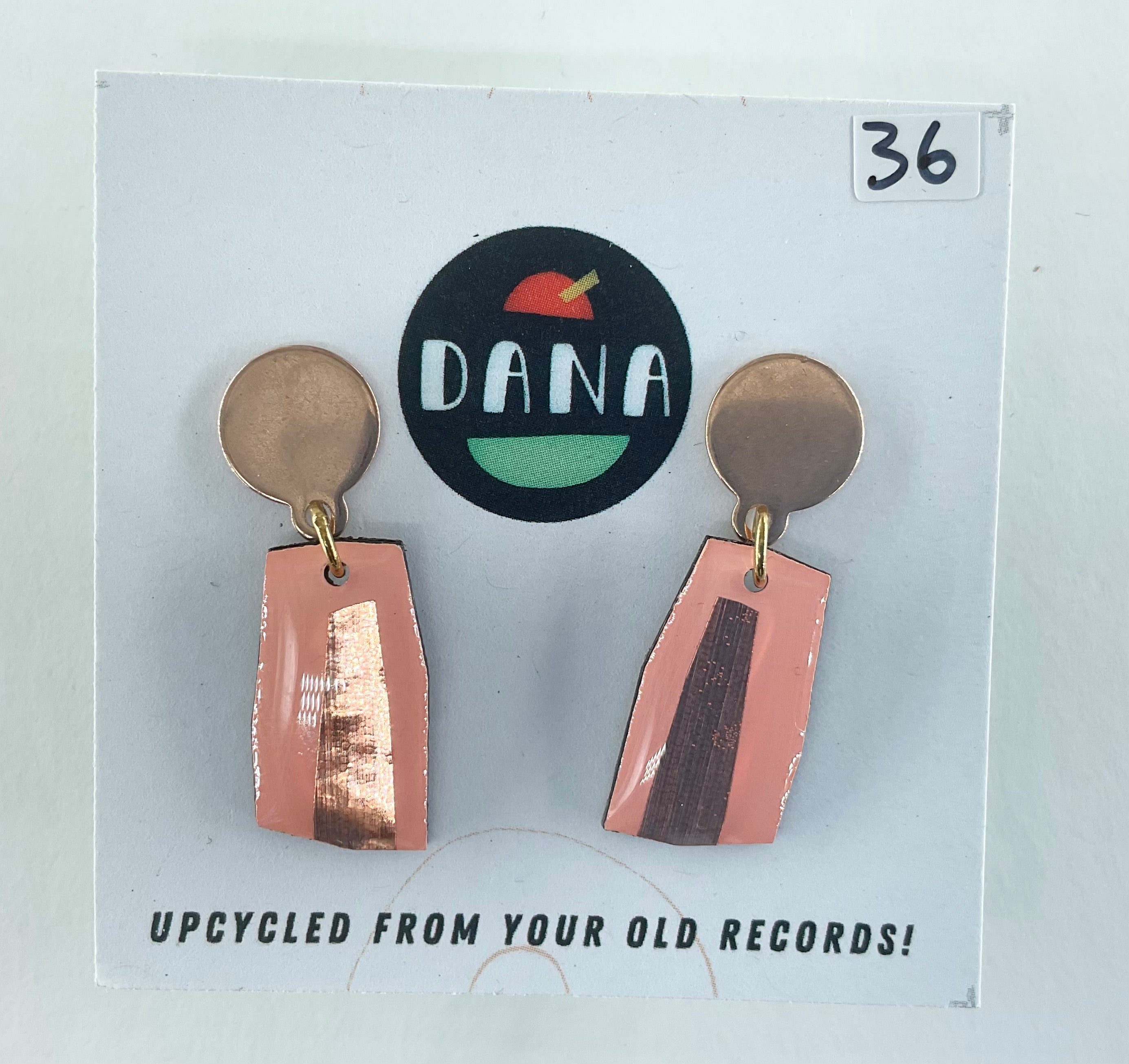 Pair of earrings on a card with 'DANA' branding and text about upcycling from old records.