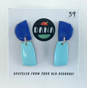 Blue and turquoise earrings on a card with 'DANA' branding and text about upcycling from old records.