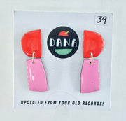 Colorful earrings on a card with 'DANA' branding and text about upcycling from old records.