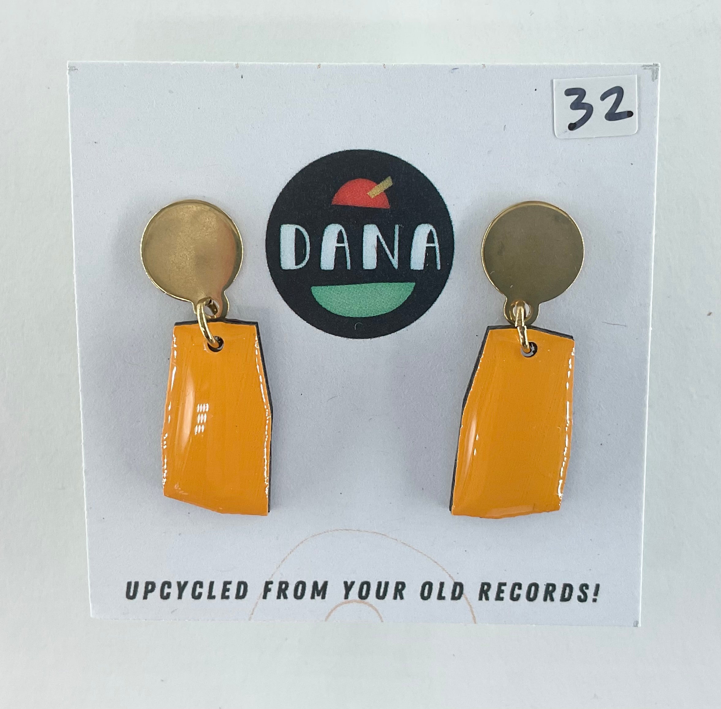 Pair of earrings on a card with 'DANA' branding and text about upcycling from old records.