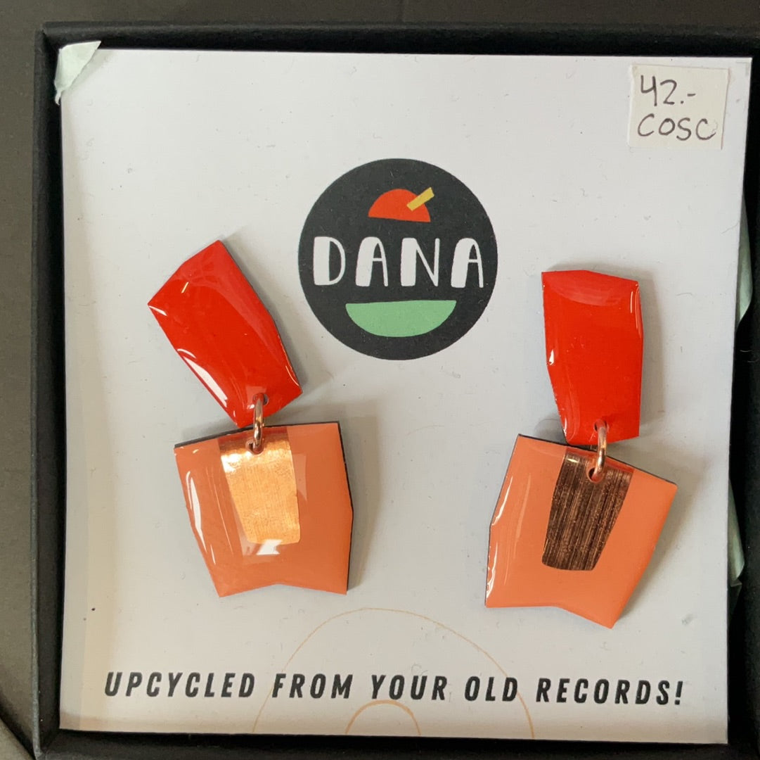 A pair of orange and peach colored upcycled vinyl record jewelry pieces with the brand logo 'Dana' on the top.