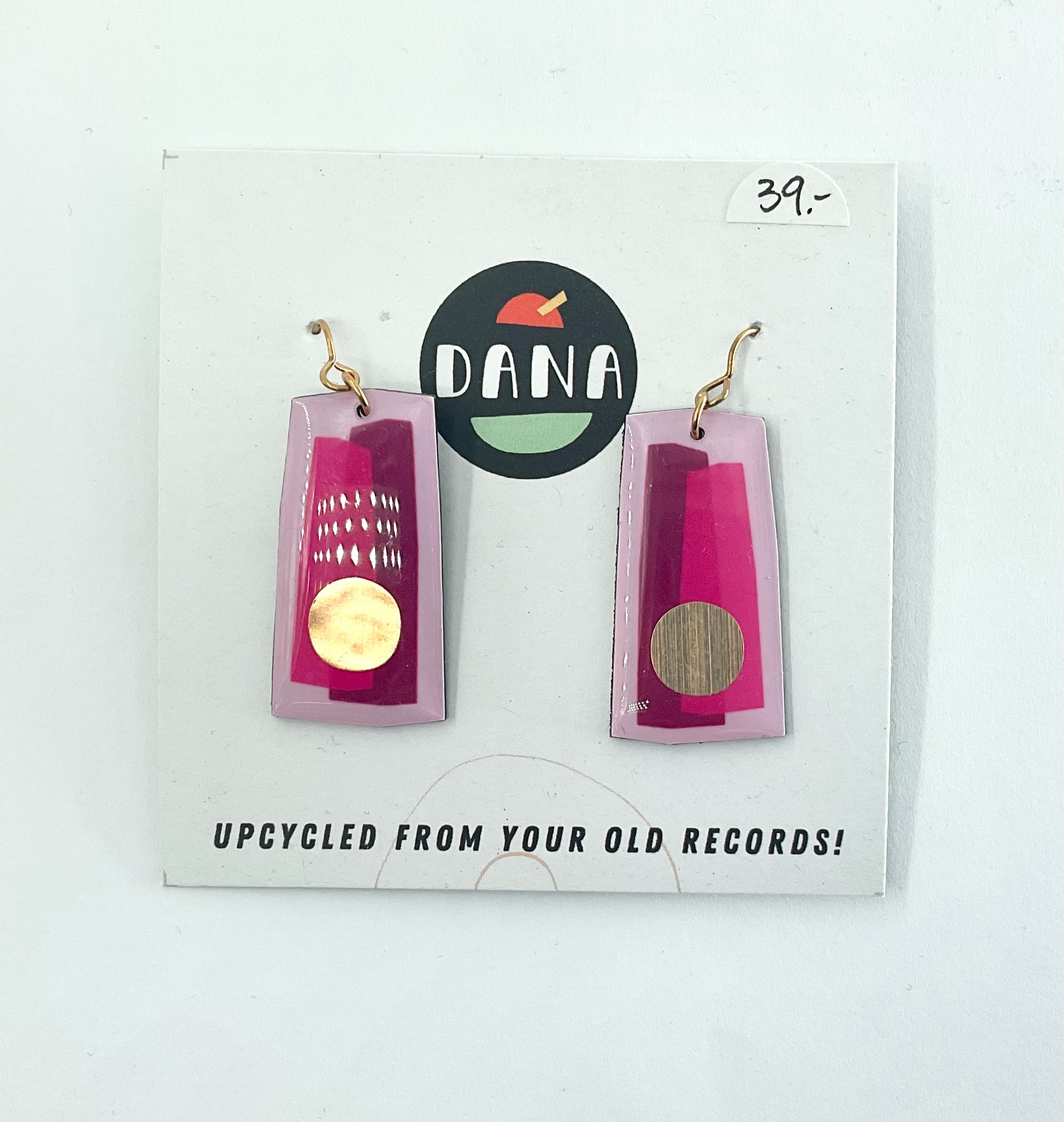 A pair of gold and pink earrings, with the Dana Jewellery brand visible, displayed on a card.