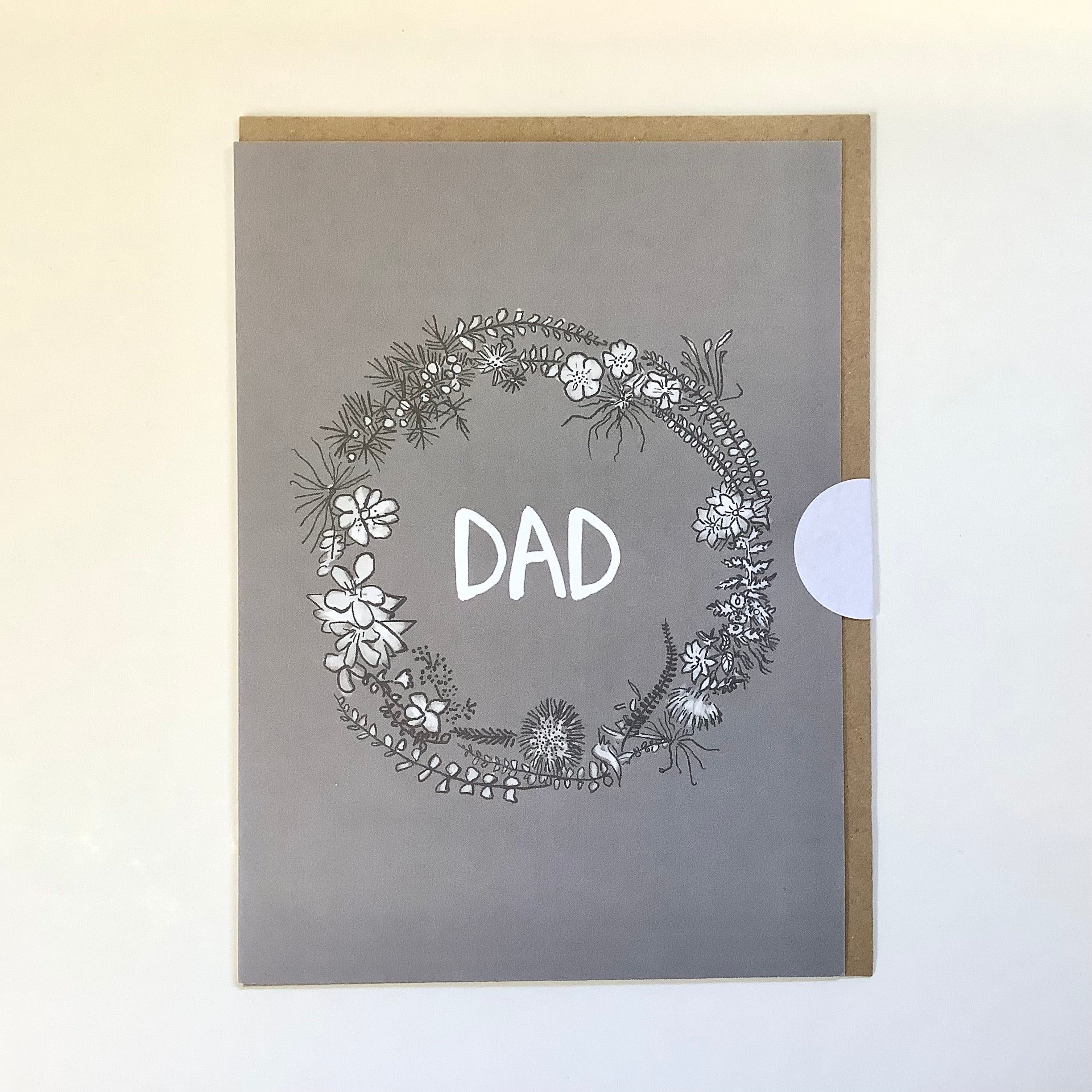 Decorative card with floral wreath and 'DAD' text on a gray background