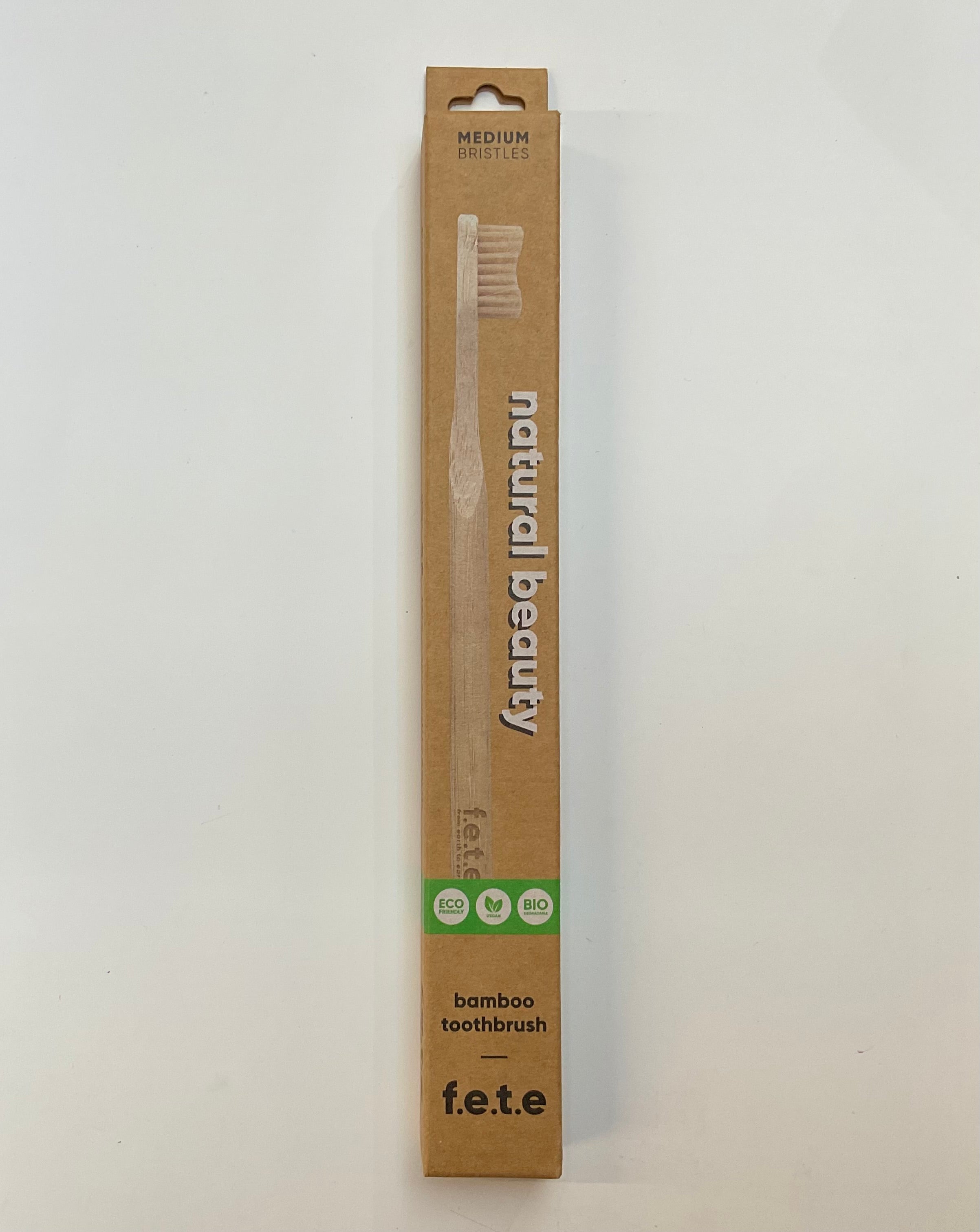 A Humble Brush brand toothbrush with a bamboo handle, packaged in an eco-friendly cardboard box with recycled materials.