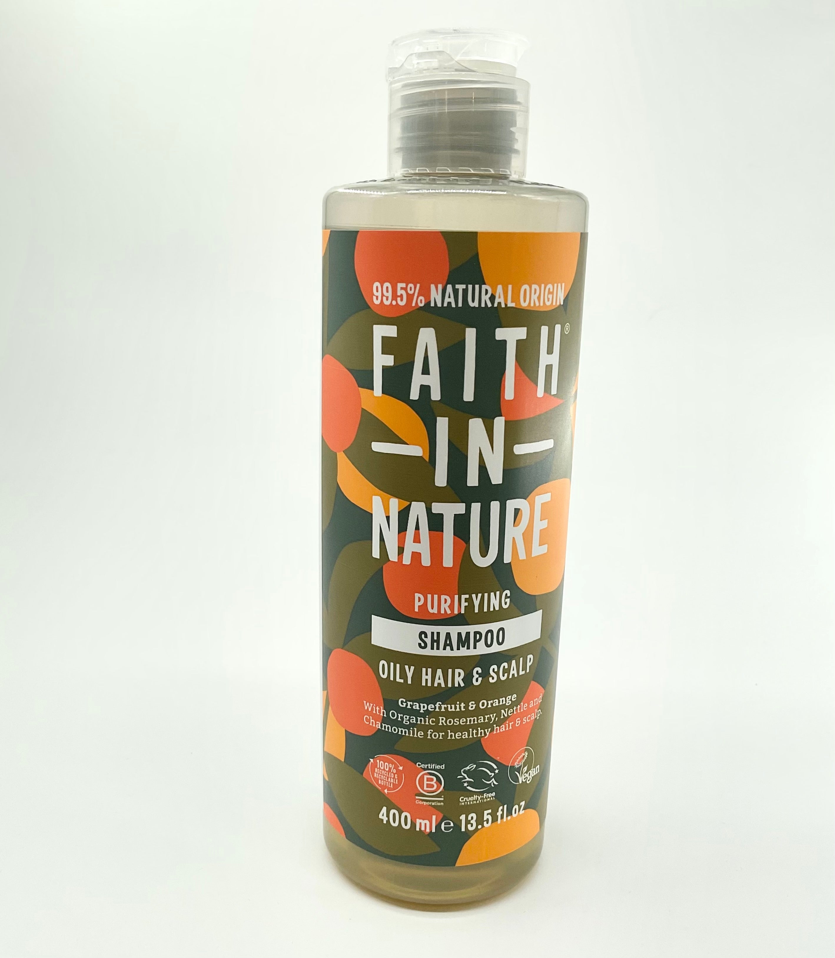 A bottle of FAITH IN NATURE shampoo with a label featuring orange and grapefruit graphics, indicating the scent of the product.