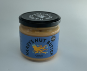 Jar of Harry's Nut Butter with a black lid on a gray background