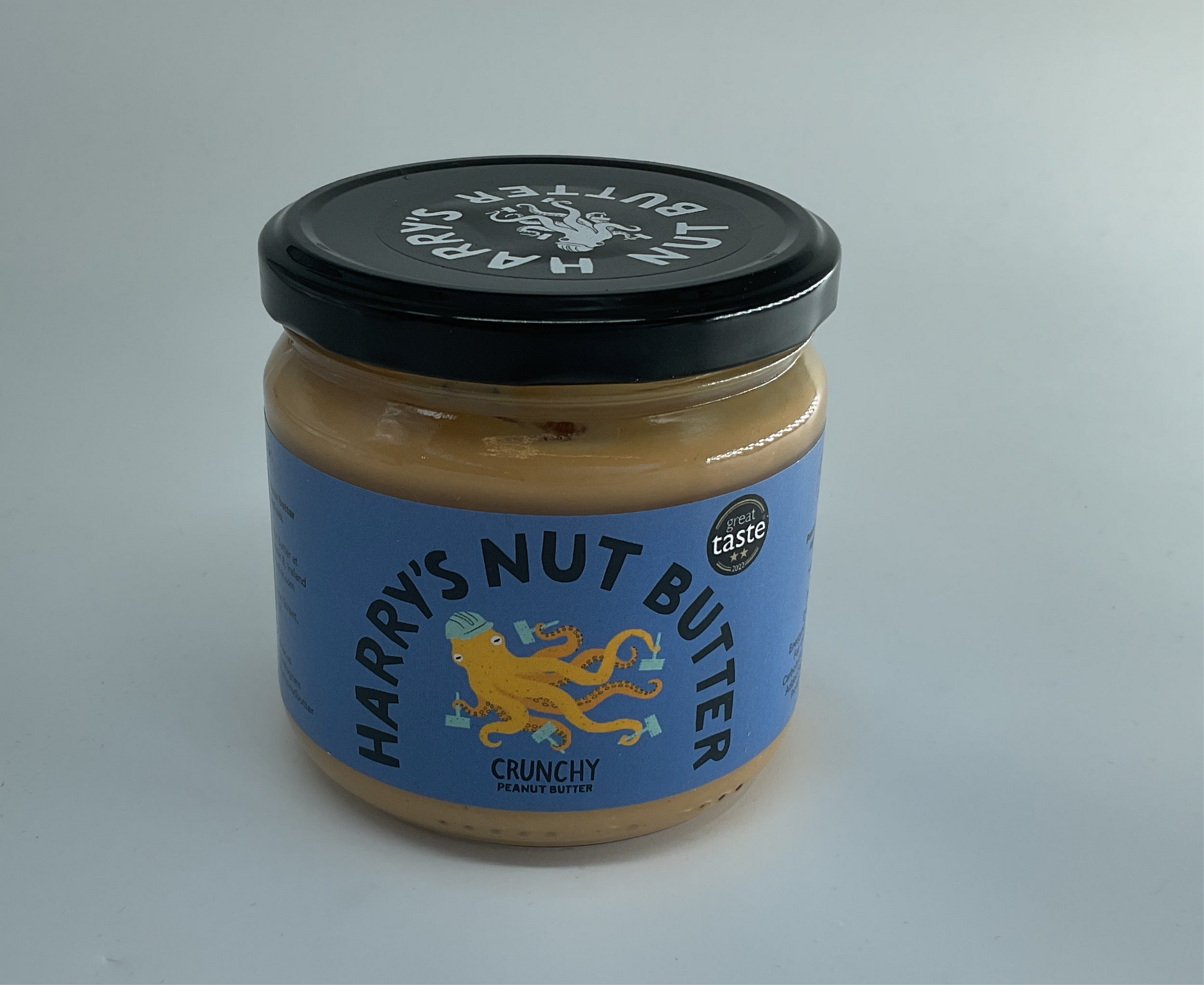 Jar of Harry's Nut Butter with a black lid on a gray background