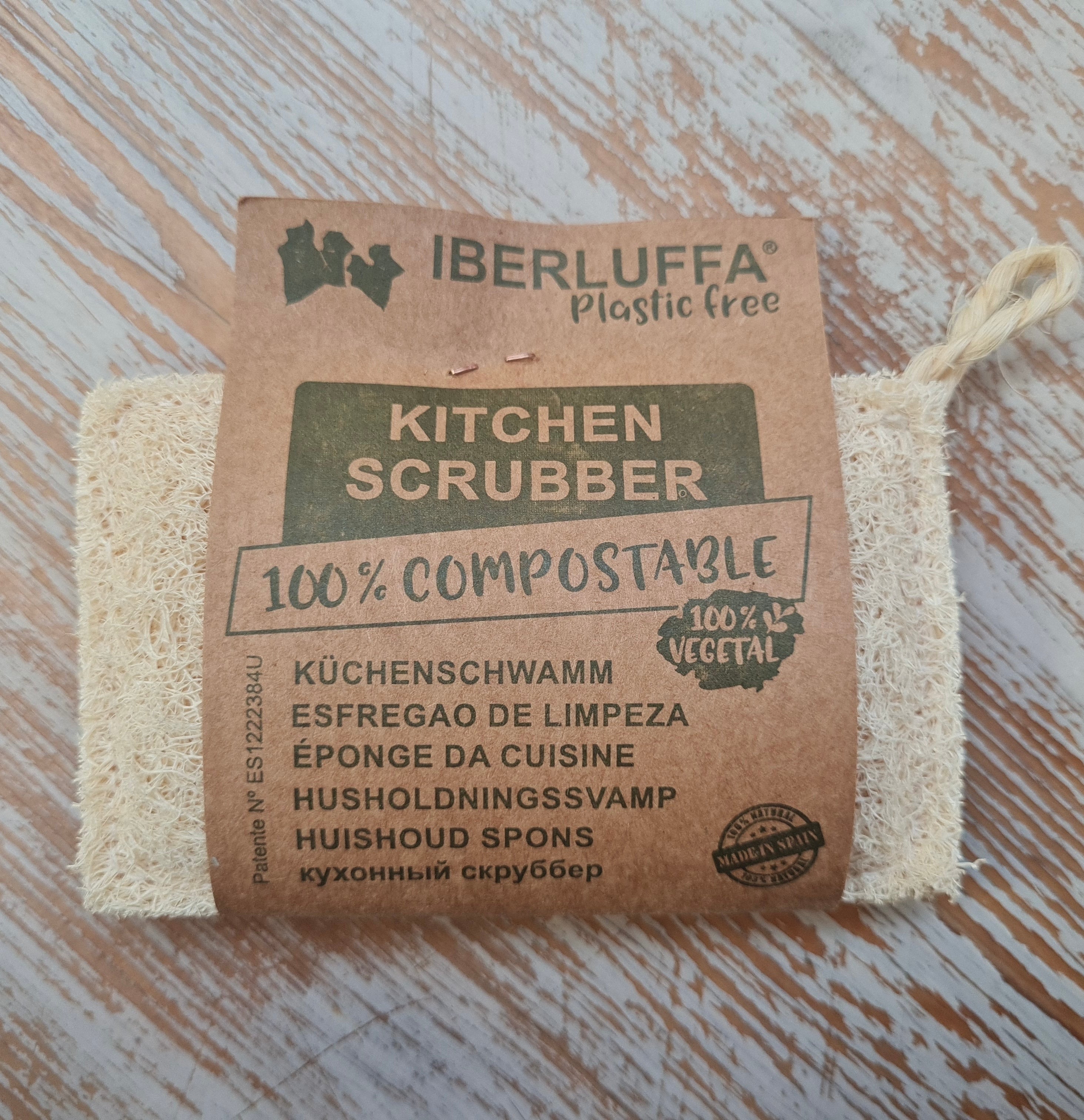 Iberluffa kitchen scrubber with compostable label on a wooden surface