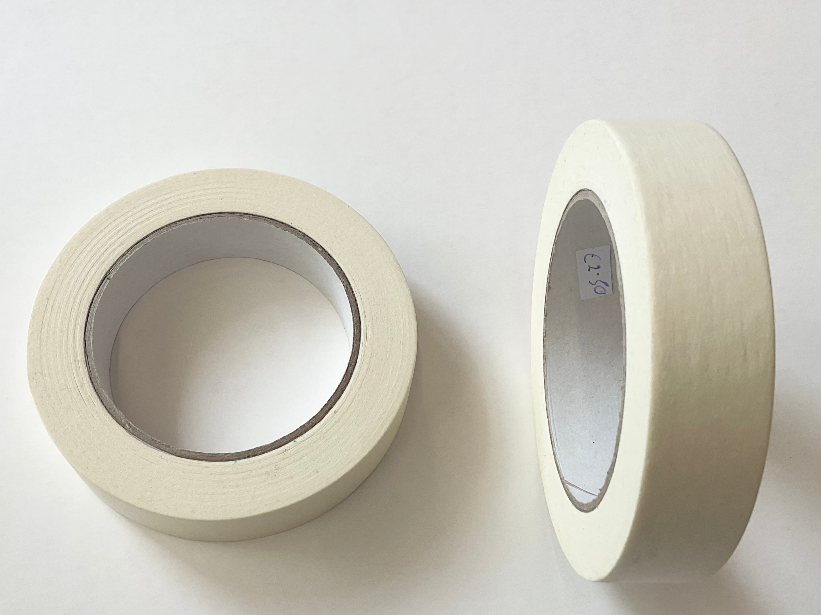 Two rolls of off-white masking tape on a plain white background, one showing the adhesive side and the other showing the cardboard core.