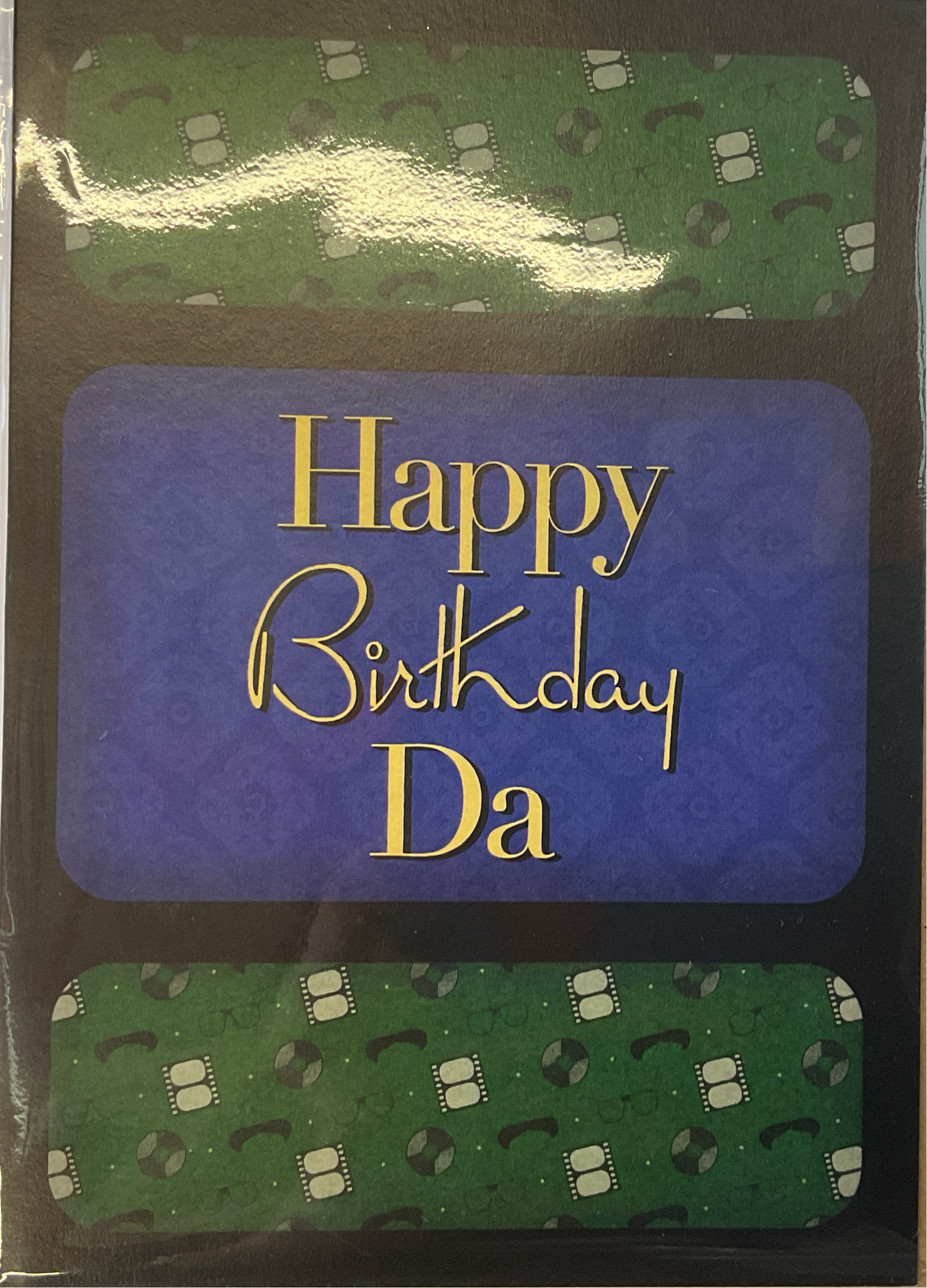 A greeting card with a blue and green pattern, featuring the text 'Happy Birthday Da' in golden letters.