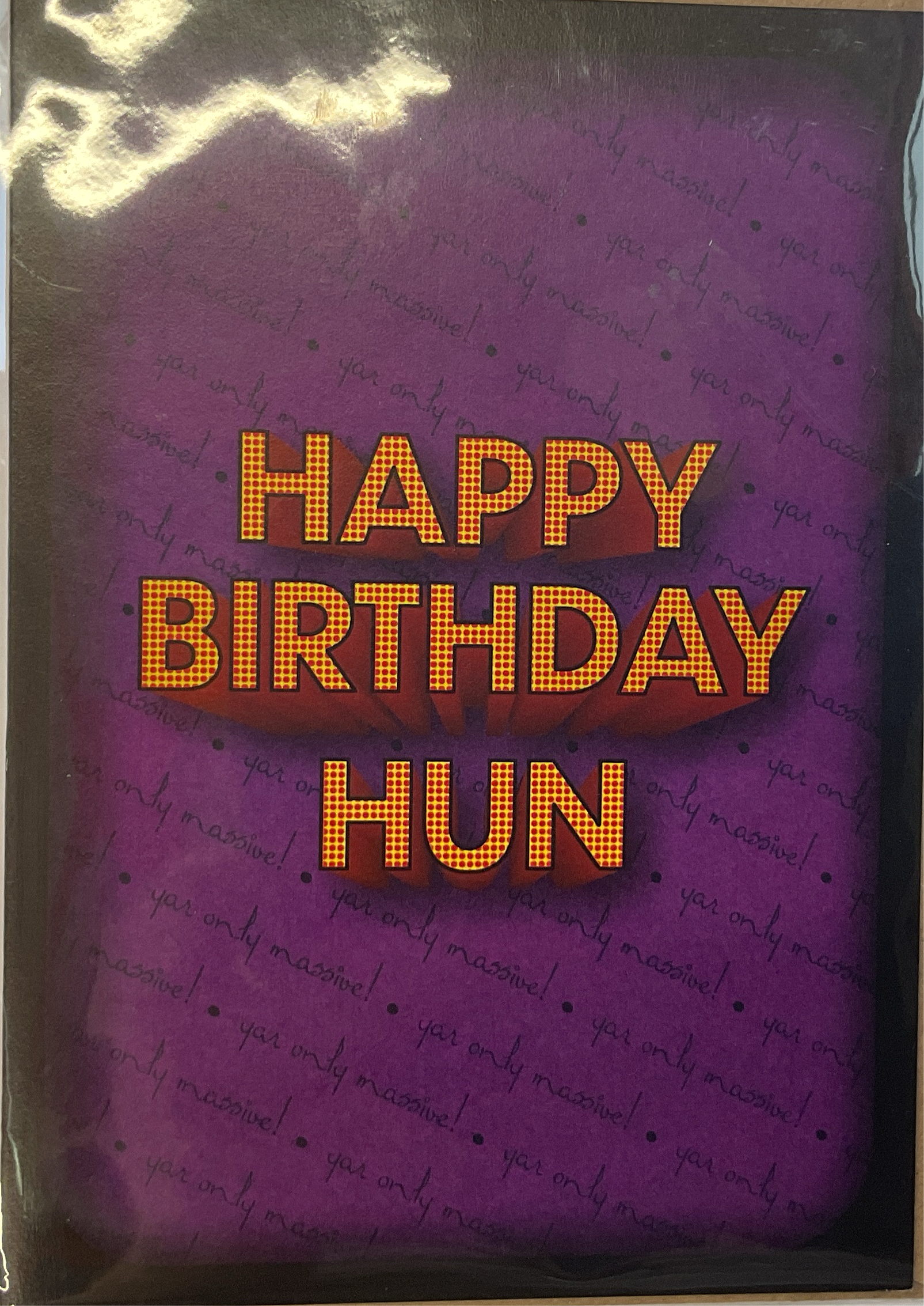 A purple greeting card with 'HAPPY BIRTHDAY HUN' written in orange text. The card has a textured background and comes with a brown paper envelope.