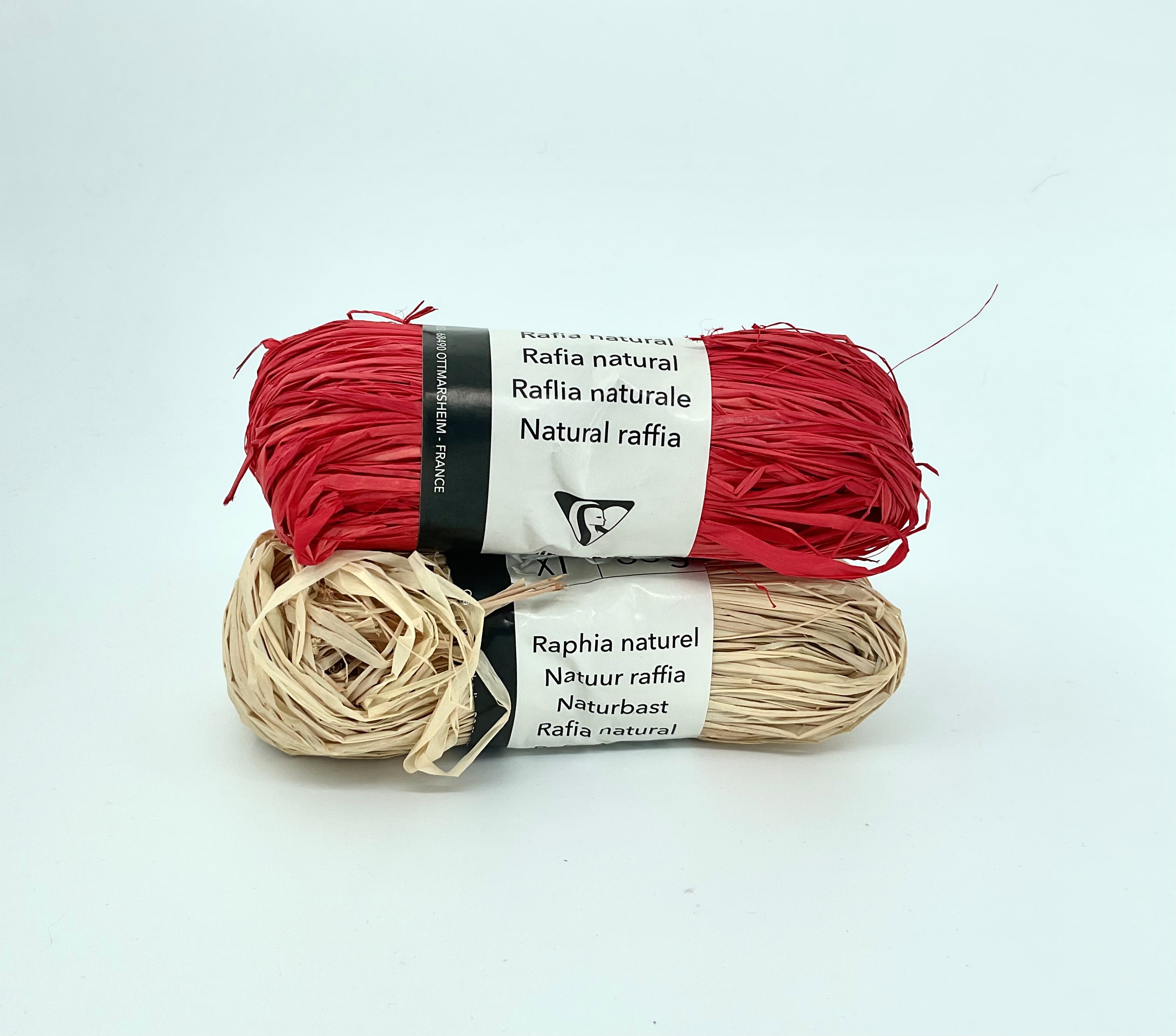 Two skeins of raffia ribbon, one in beige and one in red, labeled as 'Natural raffia'.