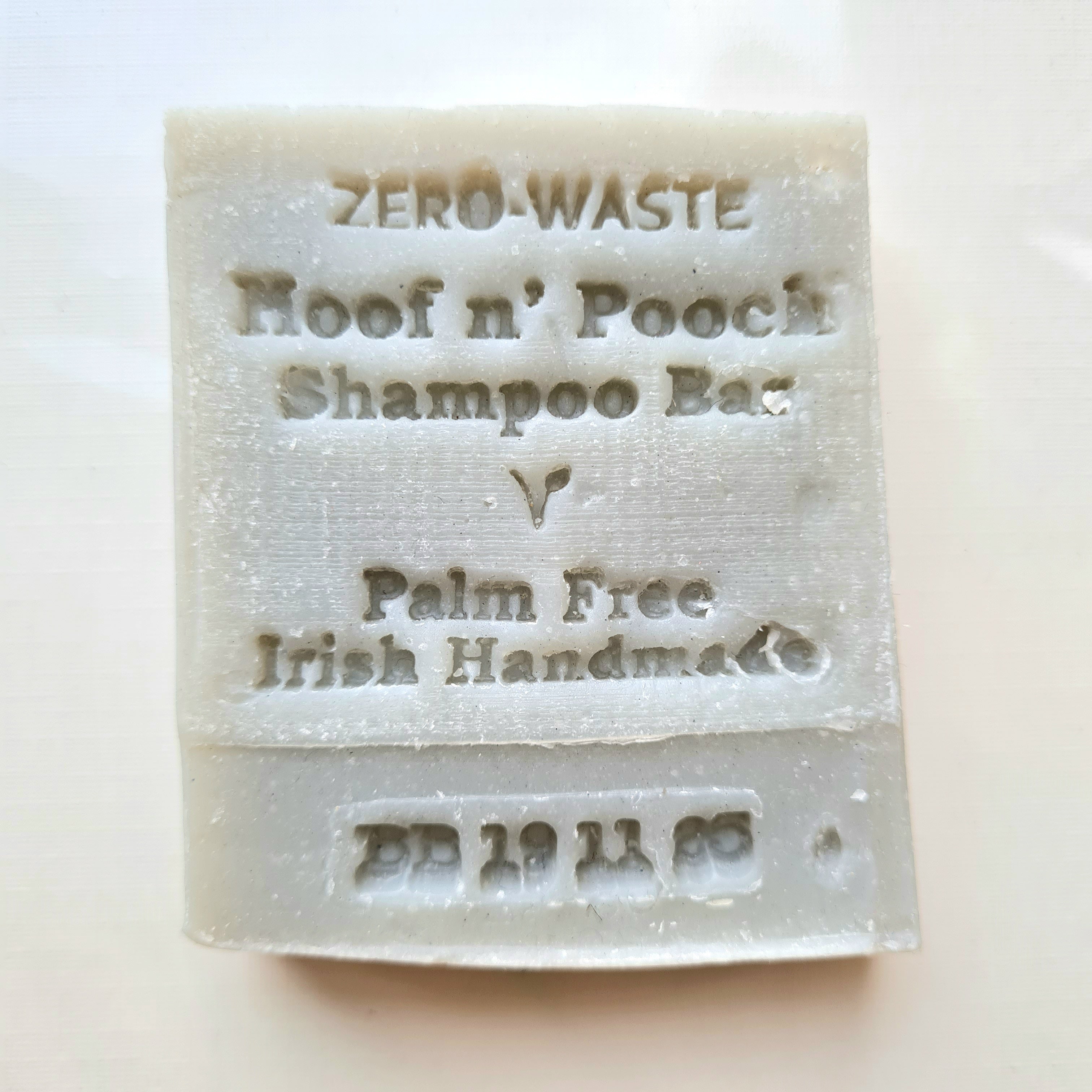 A white, solid-colored pet shampoo bar with 'ZERO WASTE' and 'For Hoof & Pouch' printed on it, indicating that it is palm free and made in Ireland.