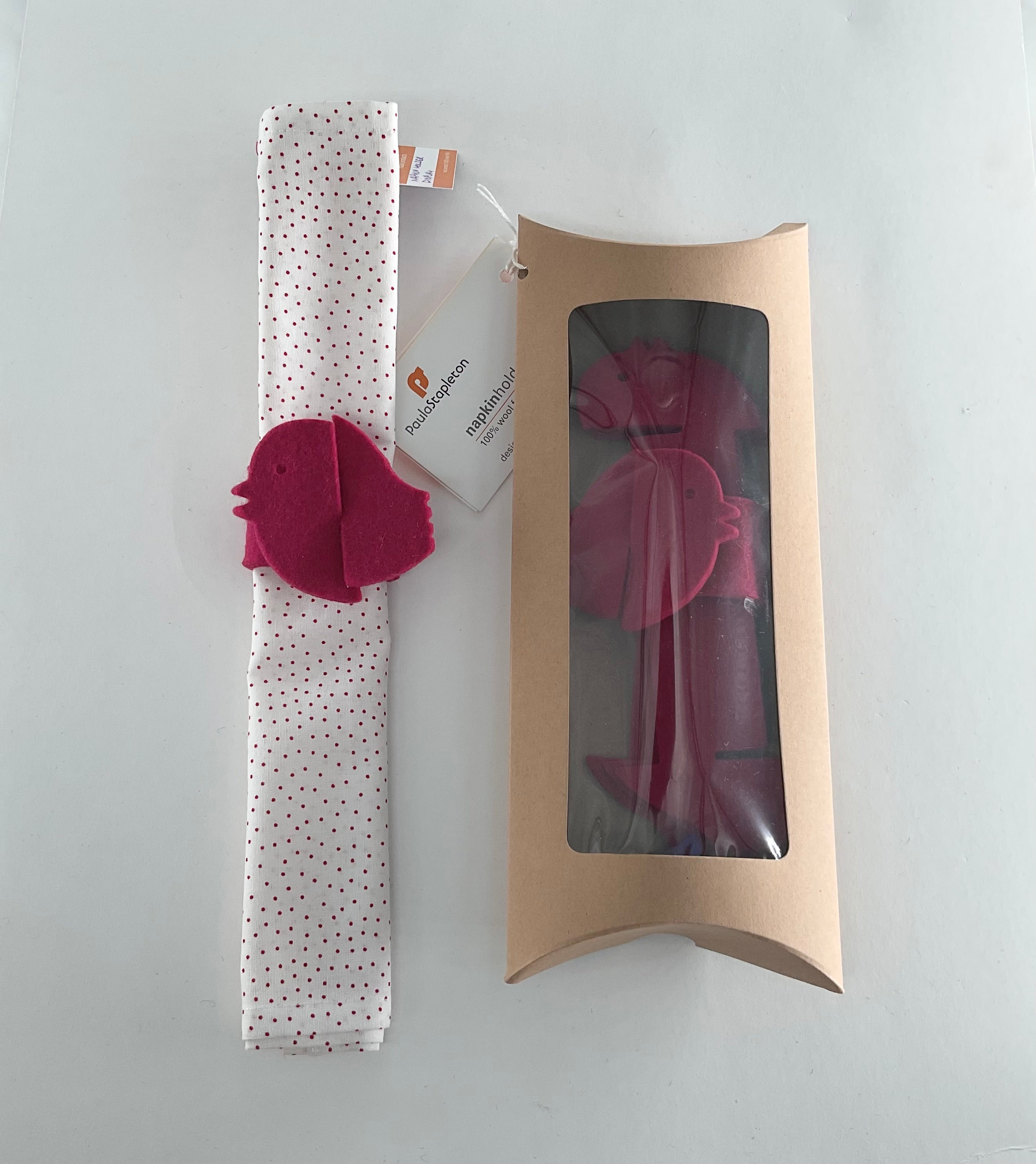 Polka dot napkin with pink bird shaped napkin holder, and packaging box on a white background