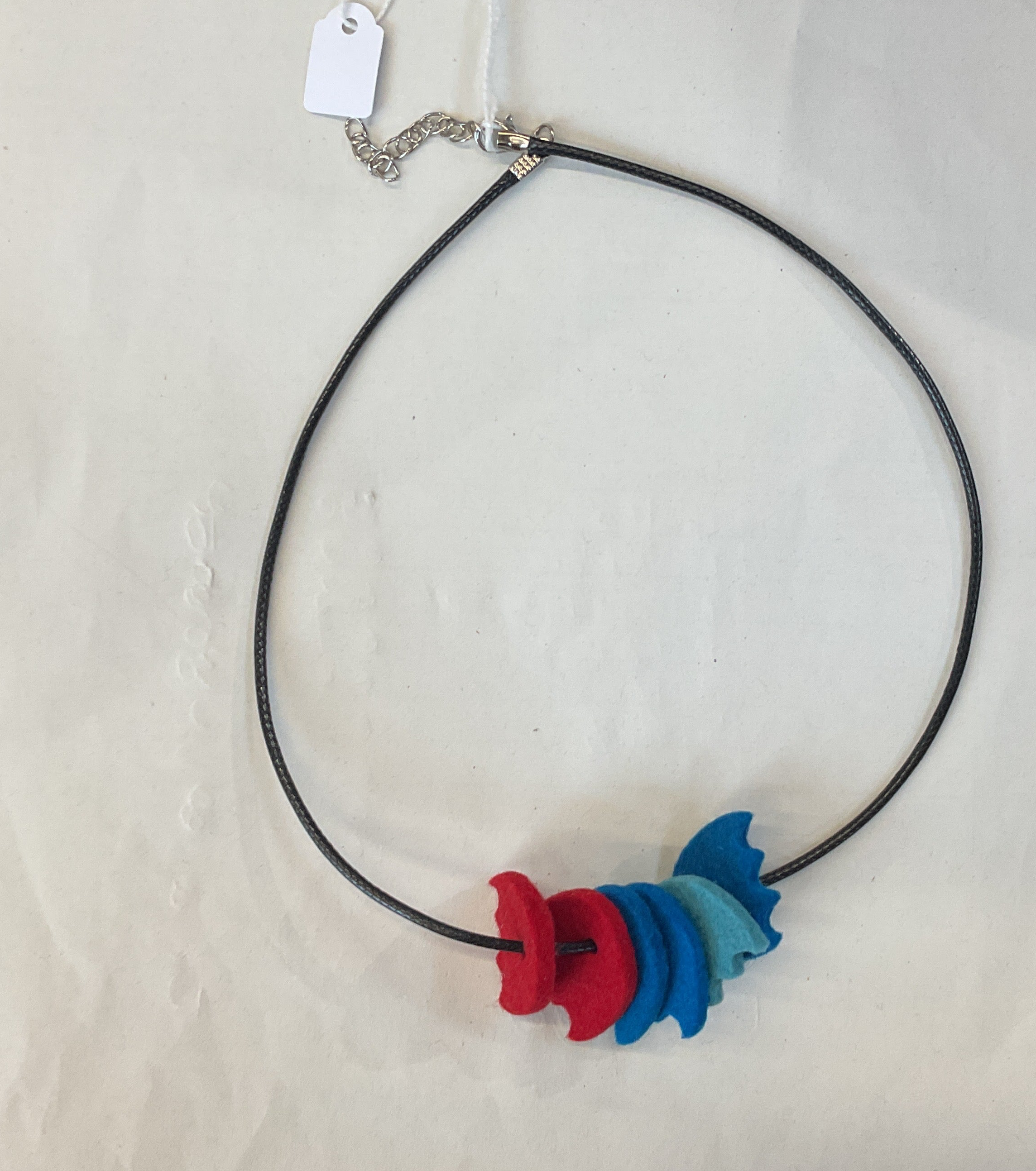 Necklace with a colorful felt pendant on a light gray background