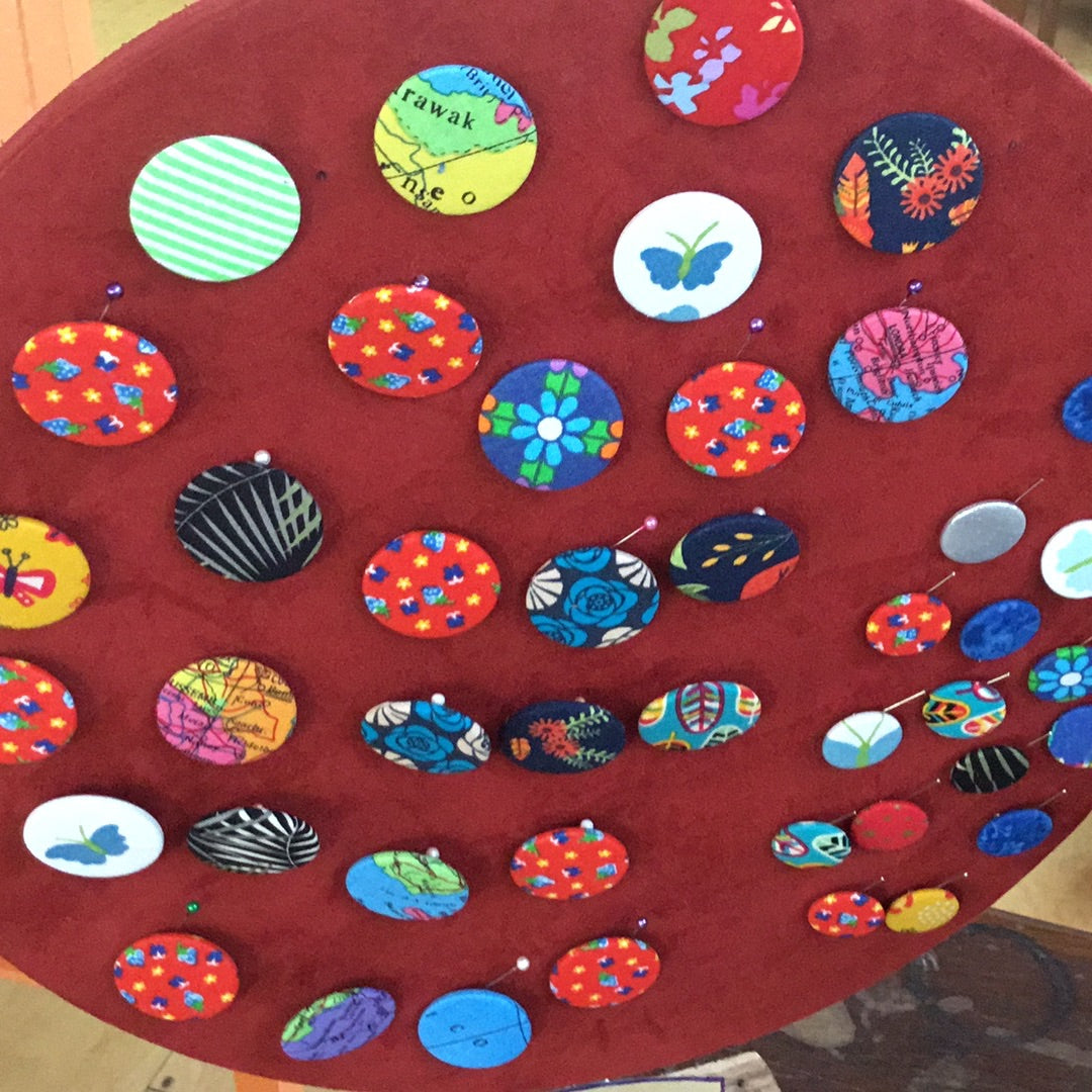 Various fabric badges pinned to felted board
