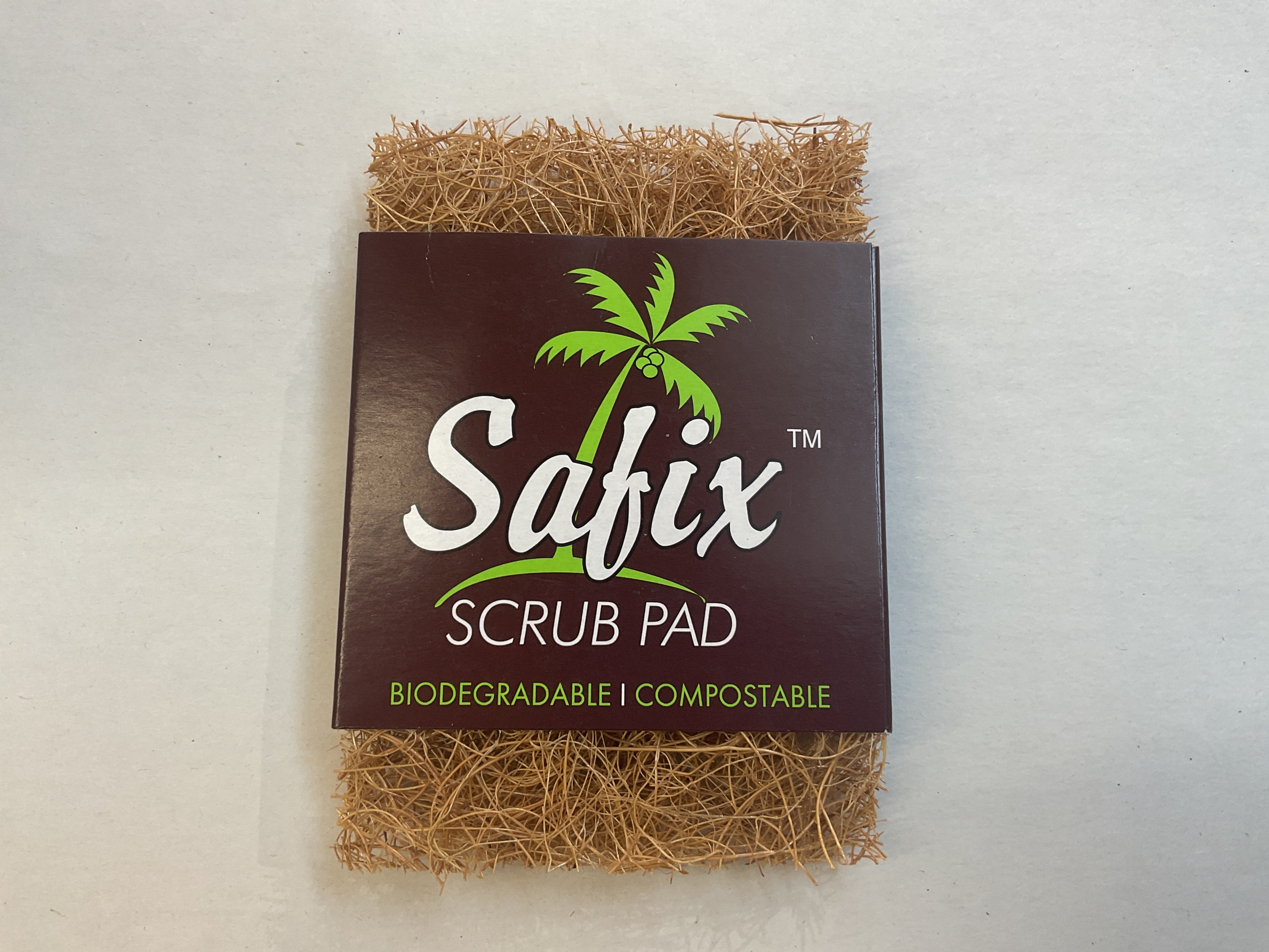A packaged Safix scrub pad made from natural coconut fibre, with the brand's logo and product information visible.