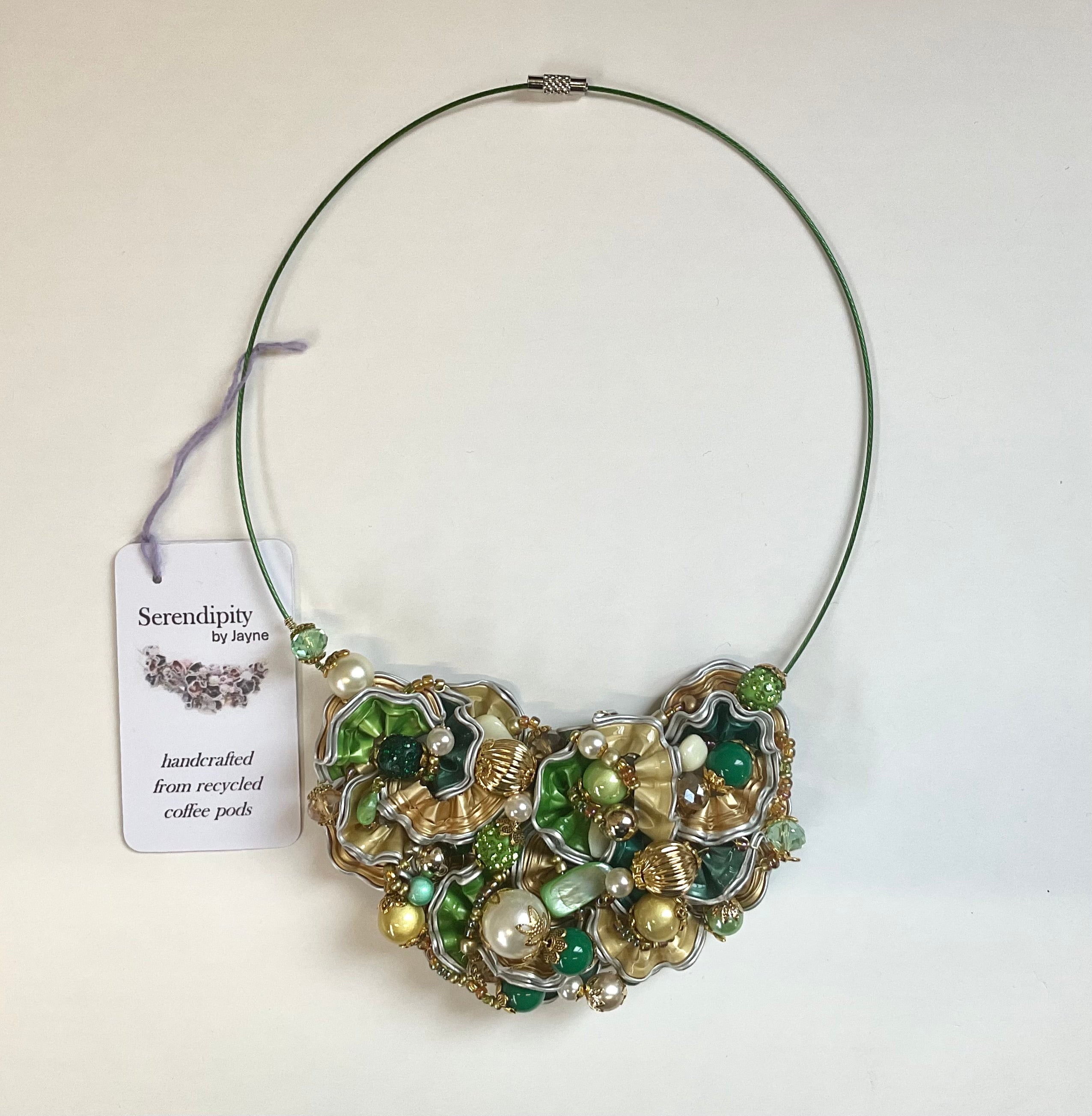 Necklace with green and gold beads on a white background