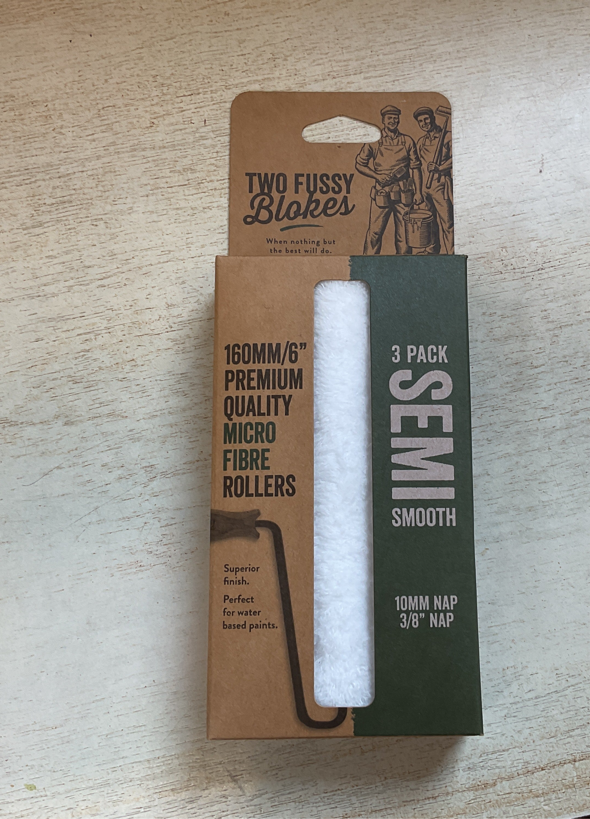 Three-pack of semi-smooth micro fibre rollers in a cardboard packaging on a wooden surface.