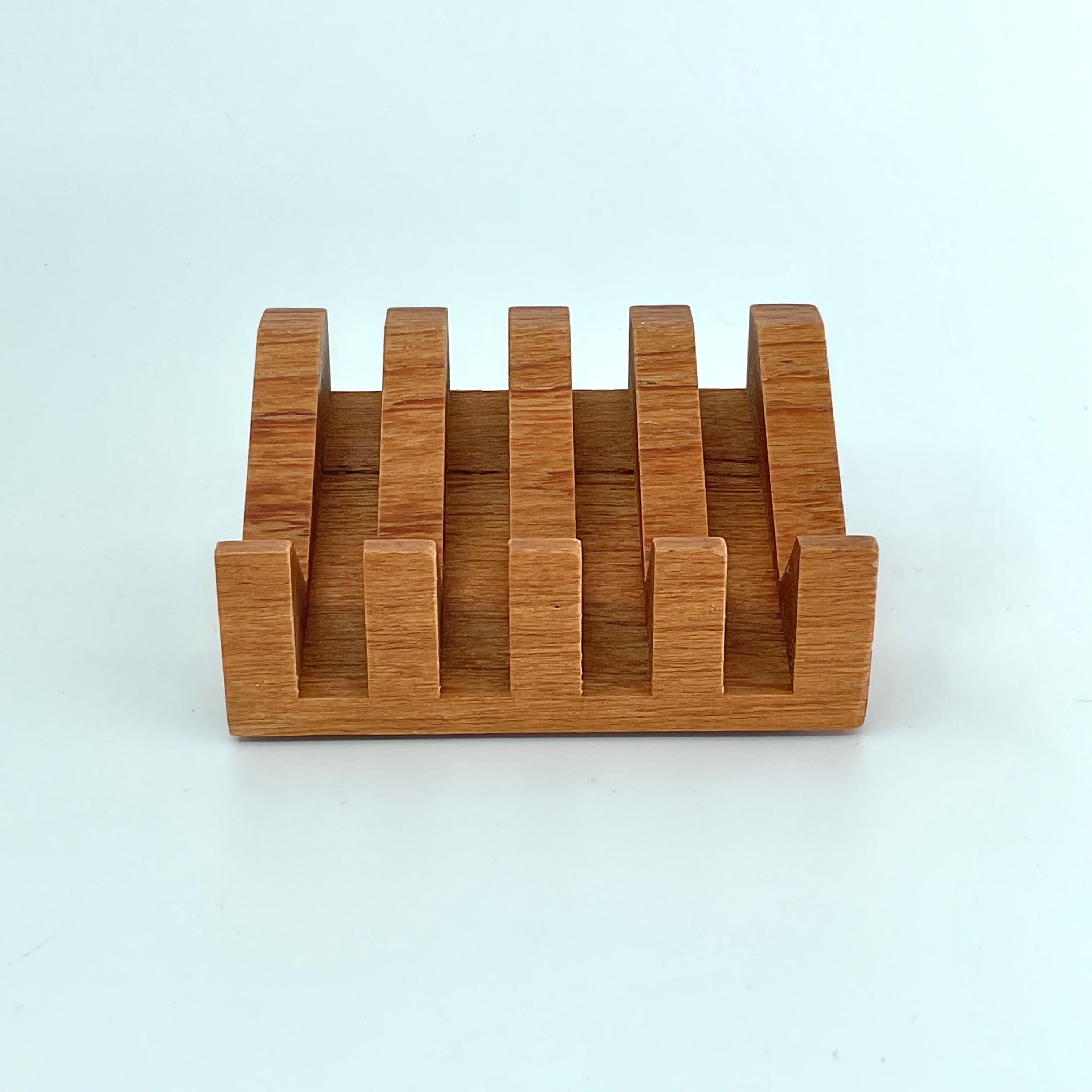 A wooden teak soap dish with wide grooves for drainage, displayed on a white background.