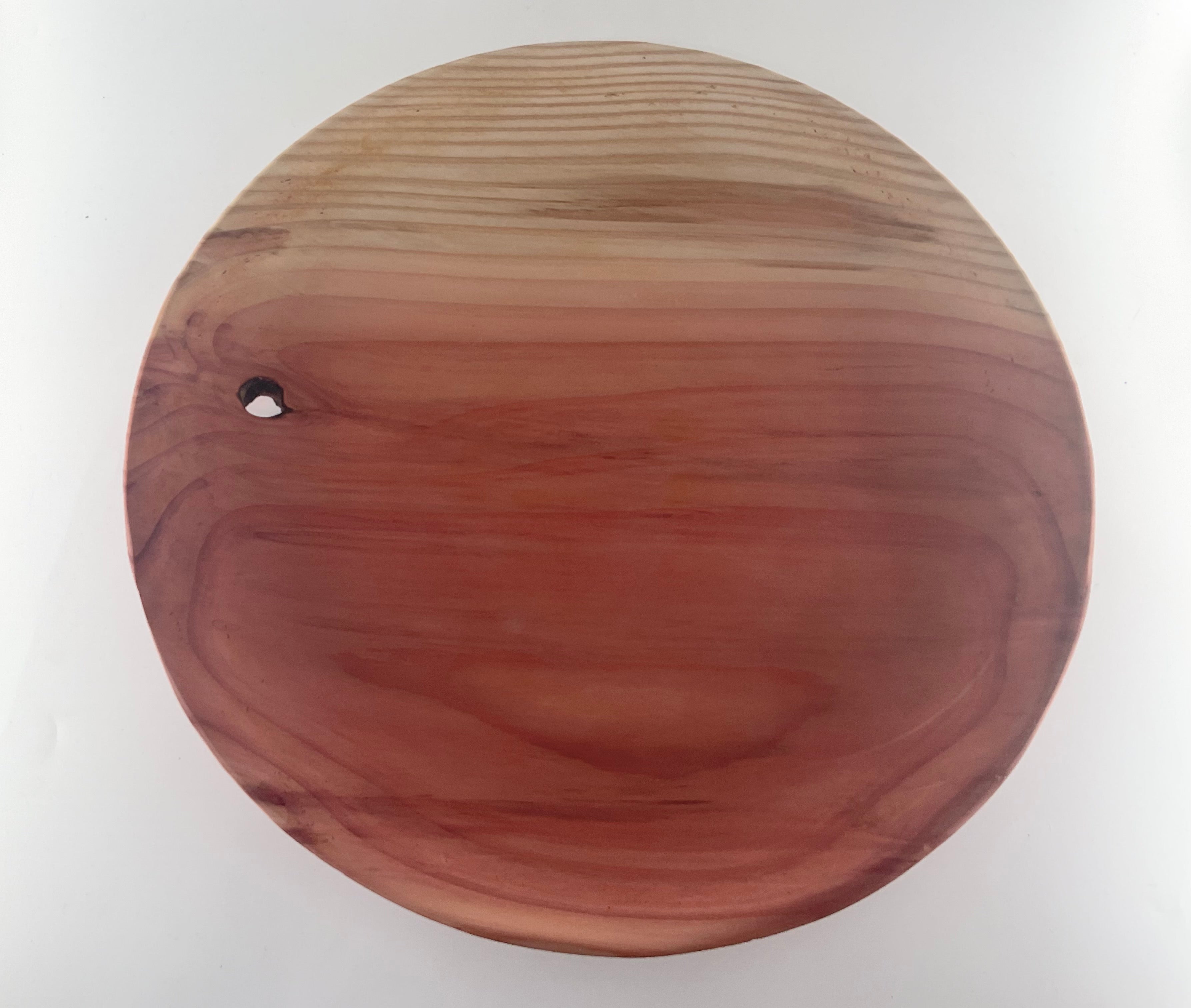 Wooden plate with a smooth finish on a white background. Featuring a knot hole.