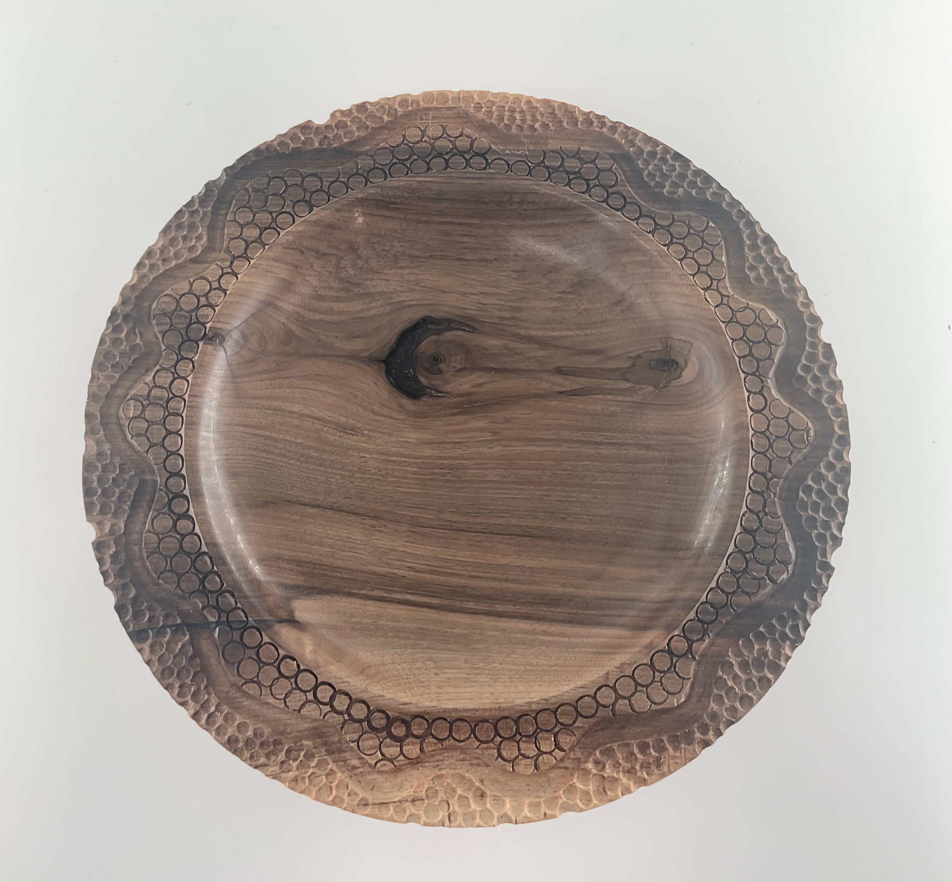 Wooden bowl with a textured rim on a white background