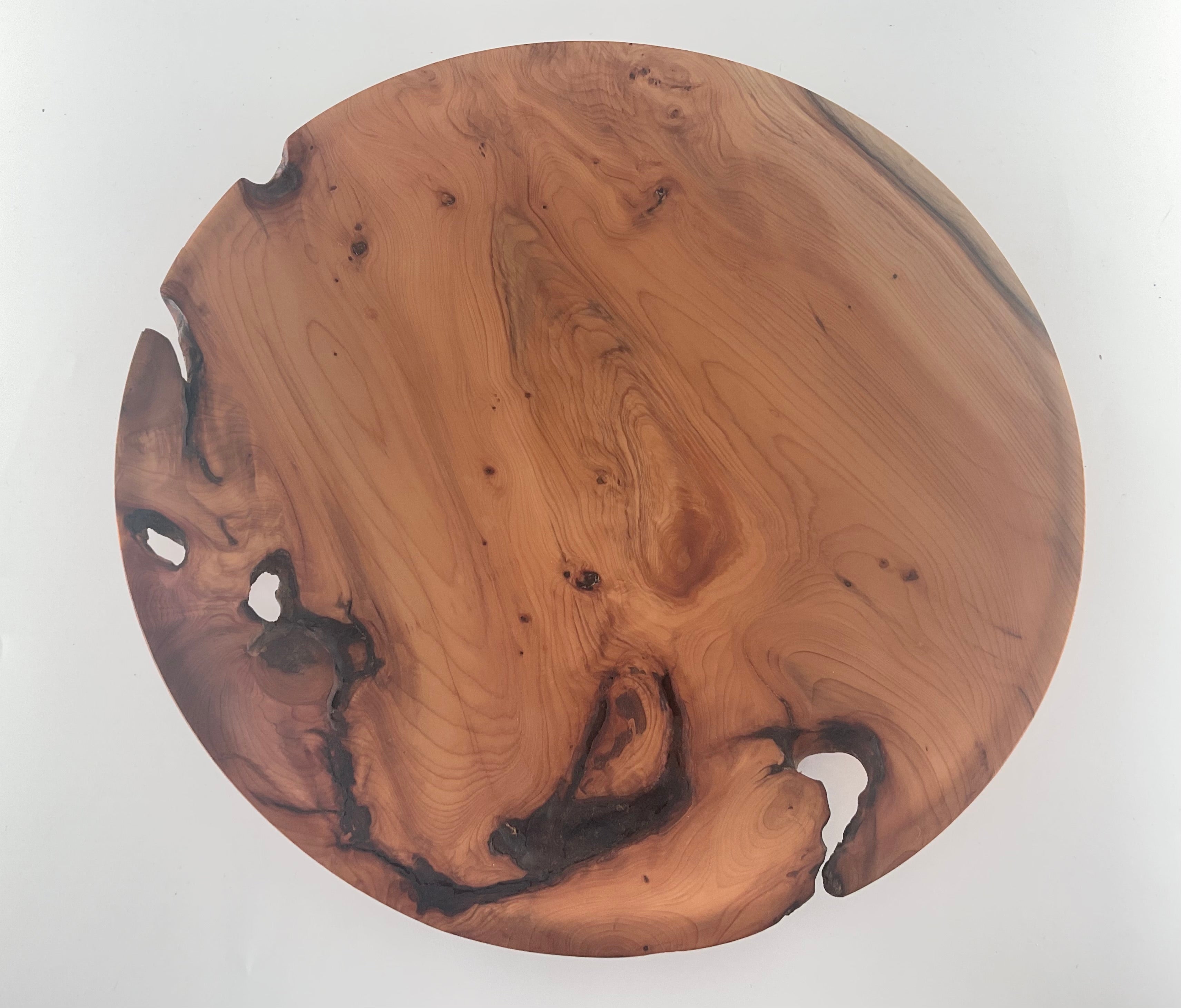 Round wooden plate  with natural grain and blemishes on a white background