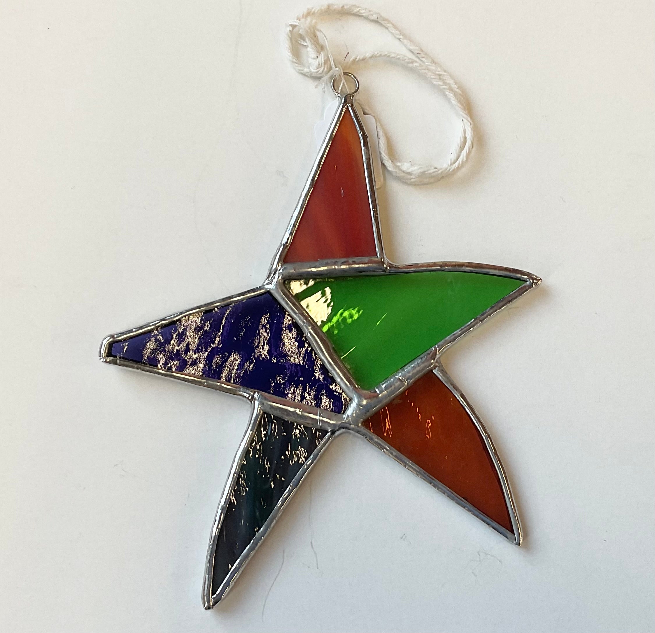 Stained glass star shape with colours blue red and green in different sections on white background
