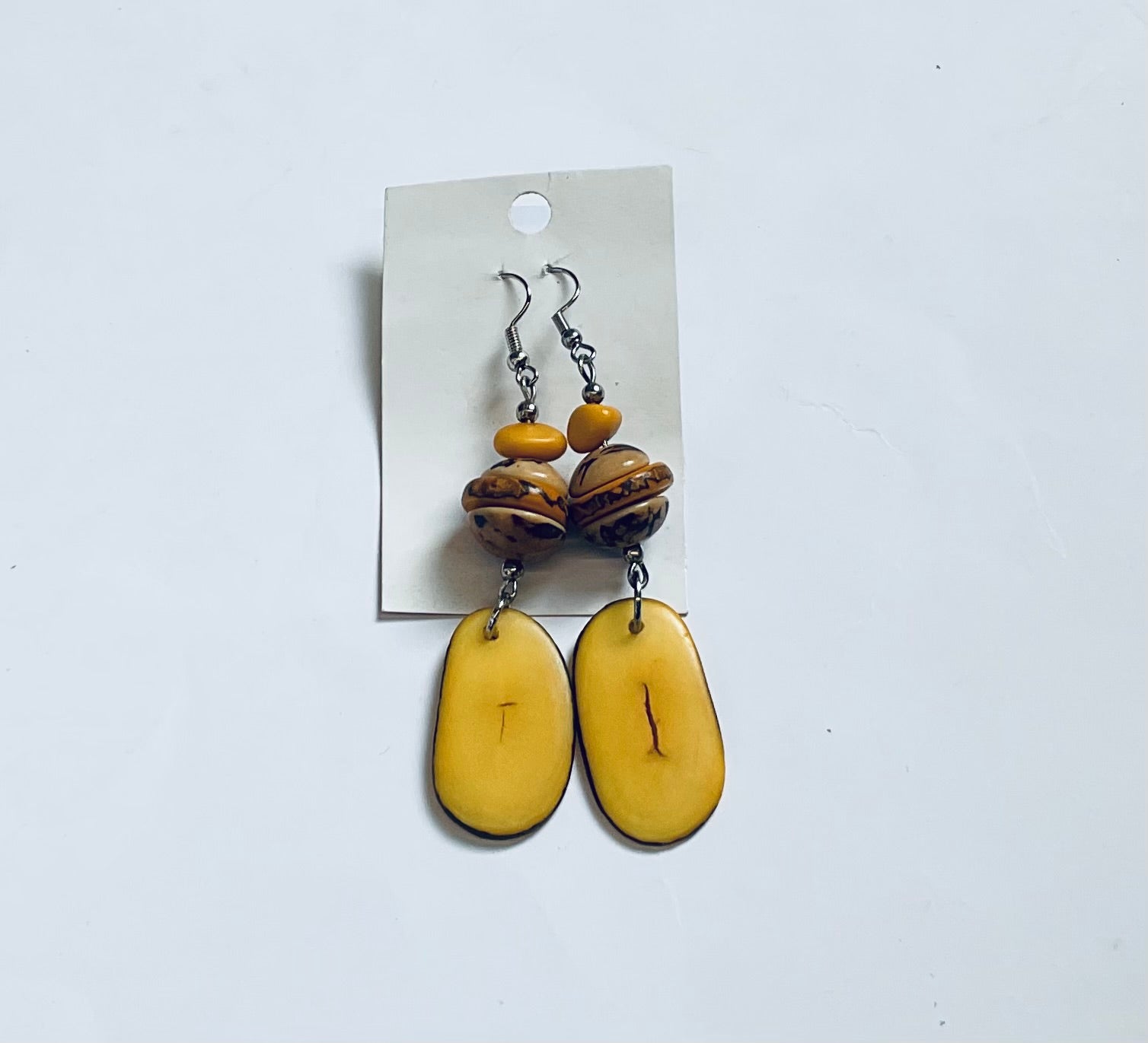 Pair of yellow and brown beaded earrings on a white background