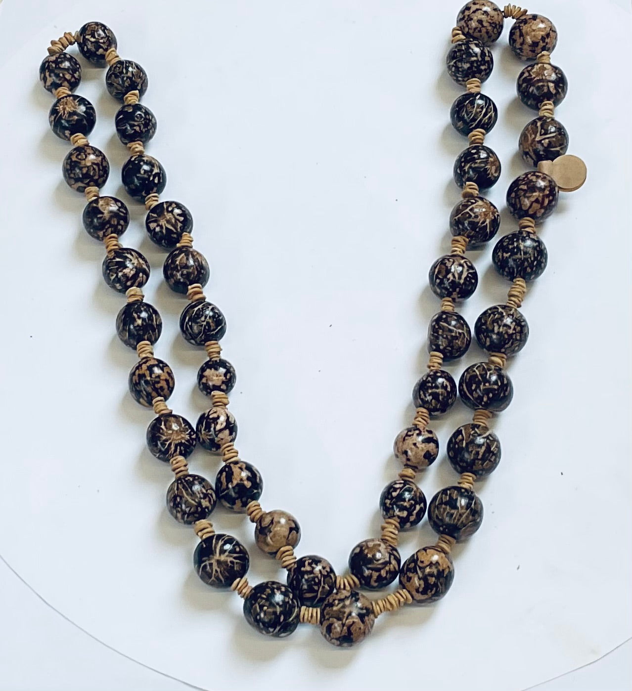 Beaded necklace with black and gold beads on a white background