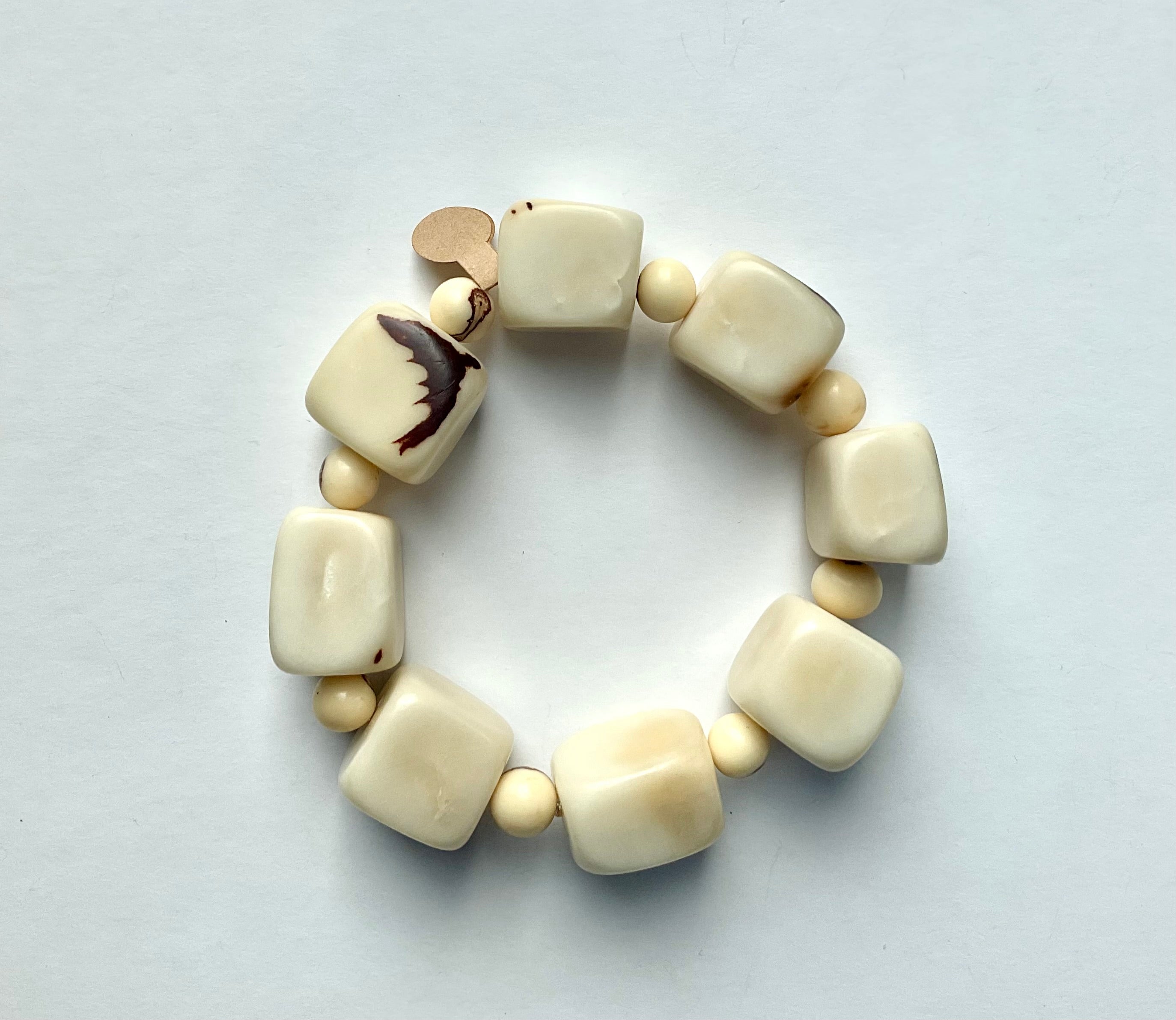 Beige beaded bracelet on a light gray background
