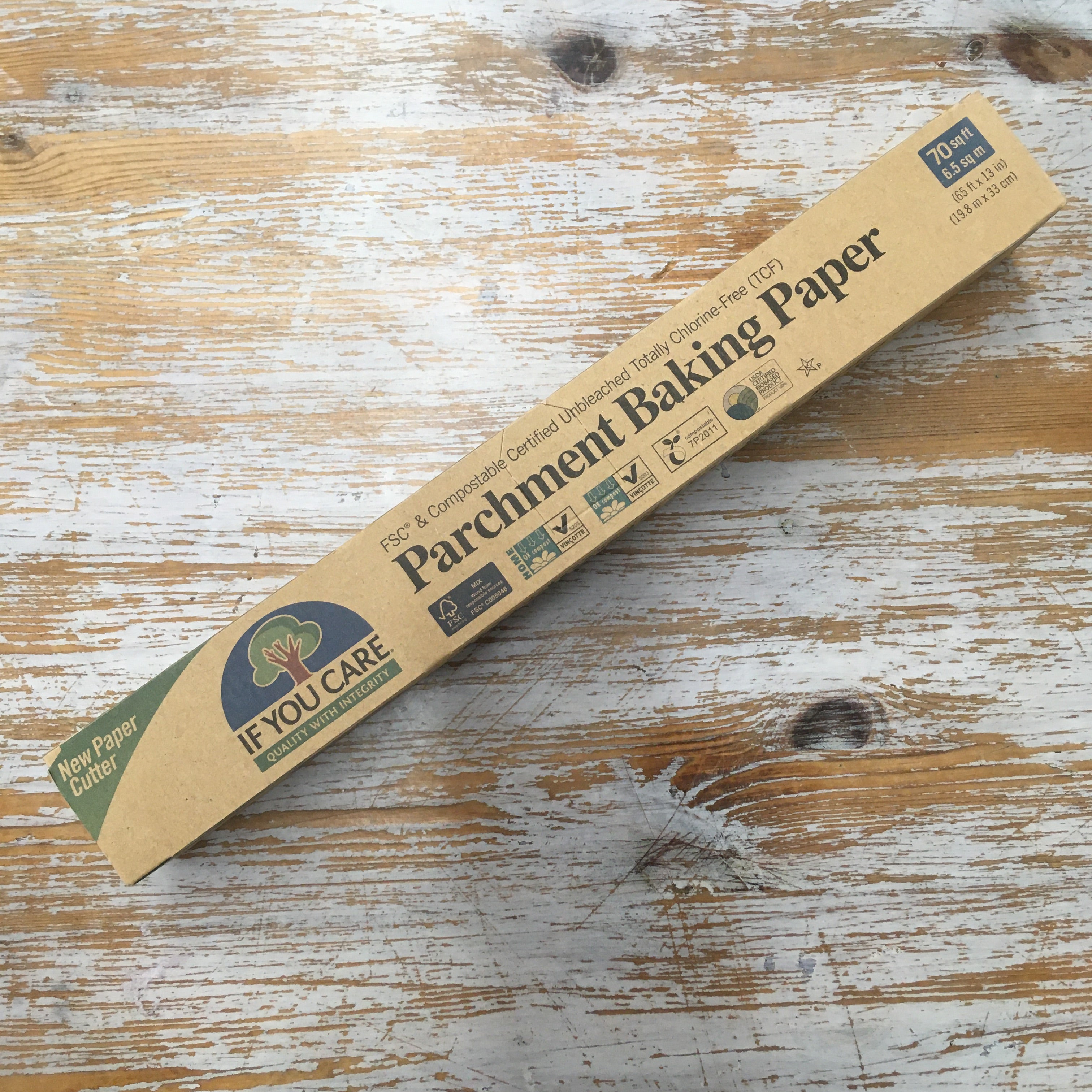 A pack of If You Care Parchment Baking Paper lying on a wooden surface.